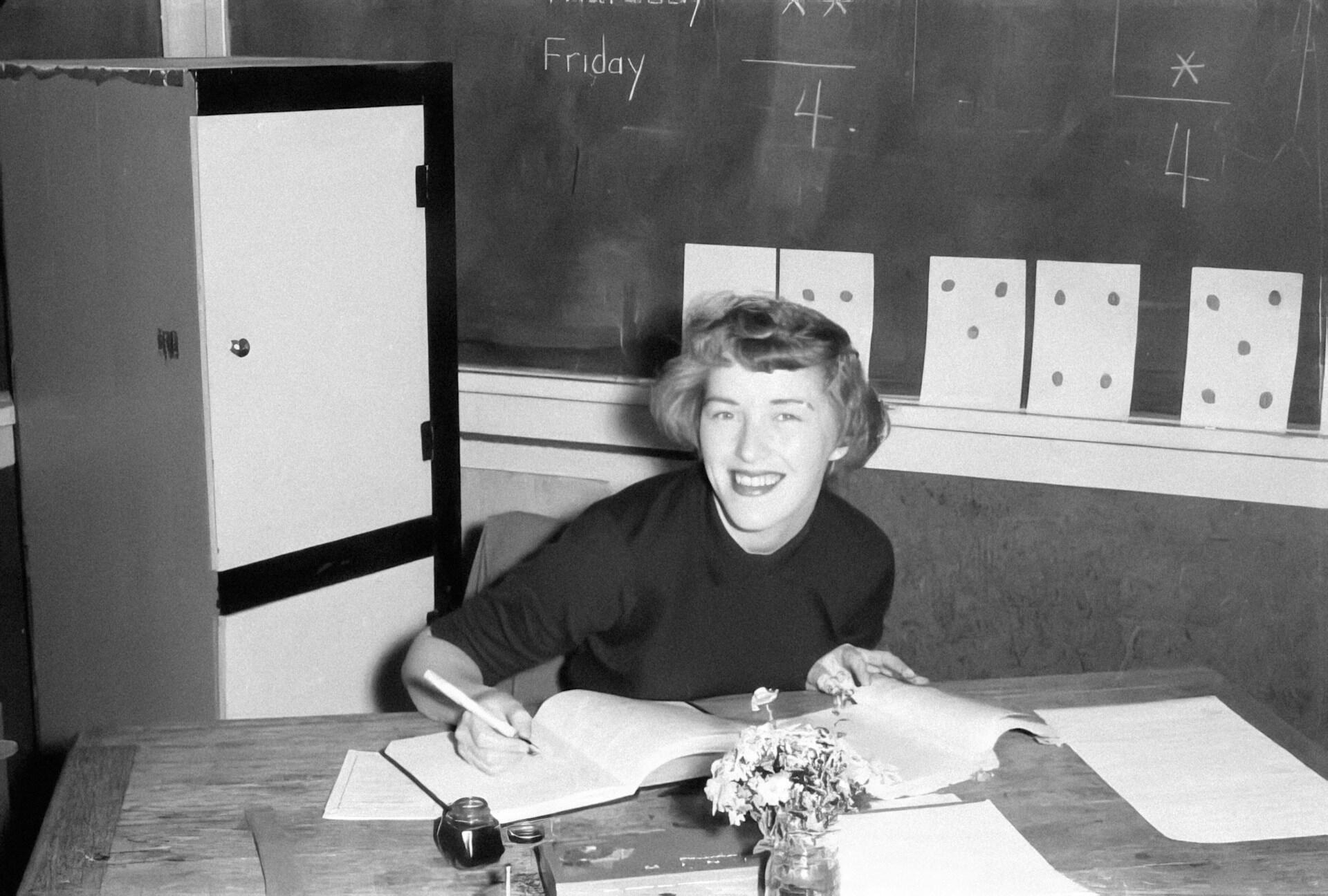 Elev arbeider med skoleoppgaver i et klasserom i et historisk sort-hvitt-fotografi