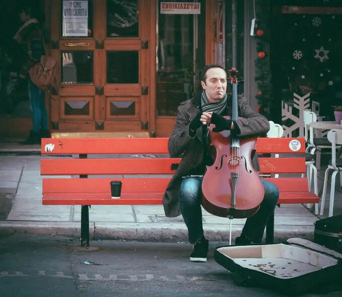 Cellist sitter med celloen støttet mellom knærne