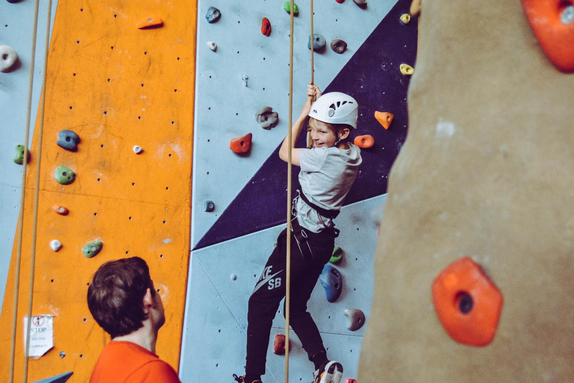 A girl learning to climb with a tutor