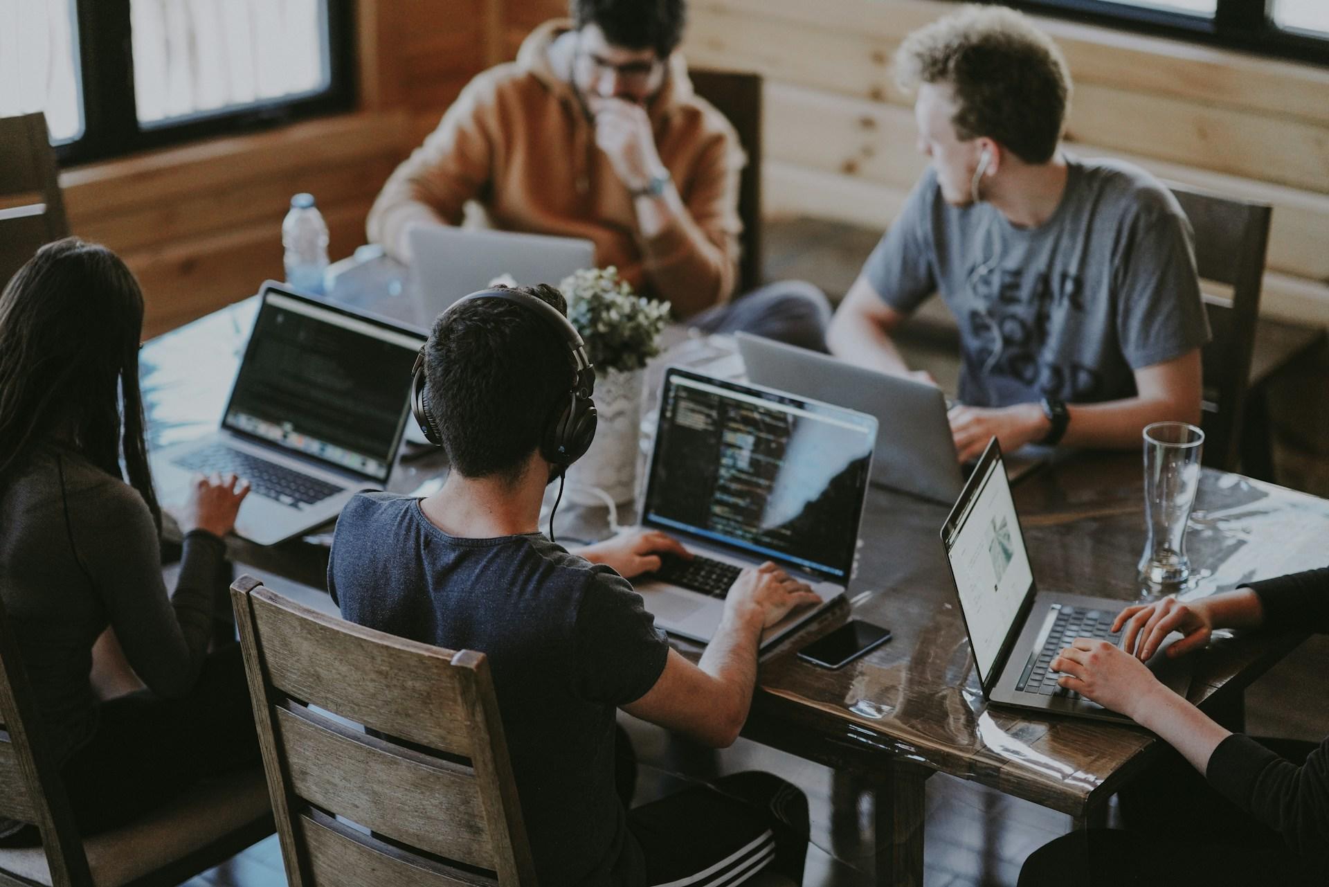 A group of students sitting together while using their laptops.