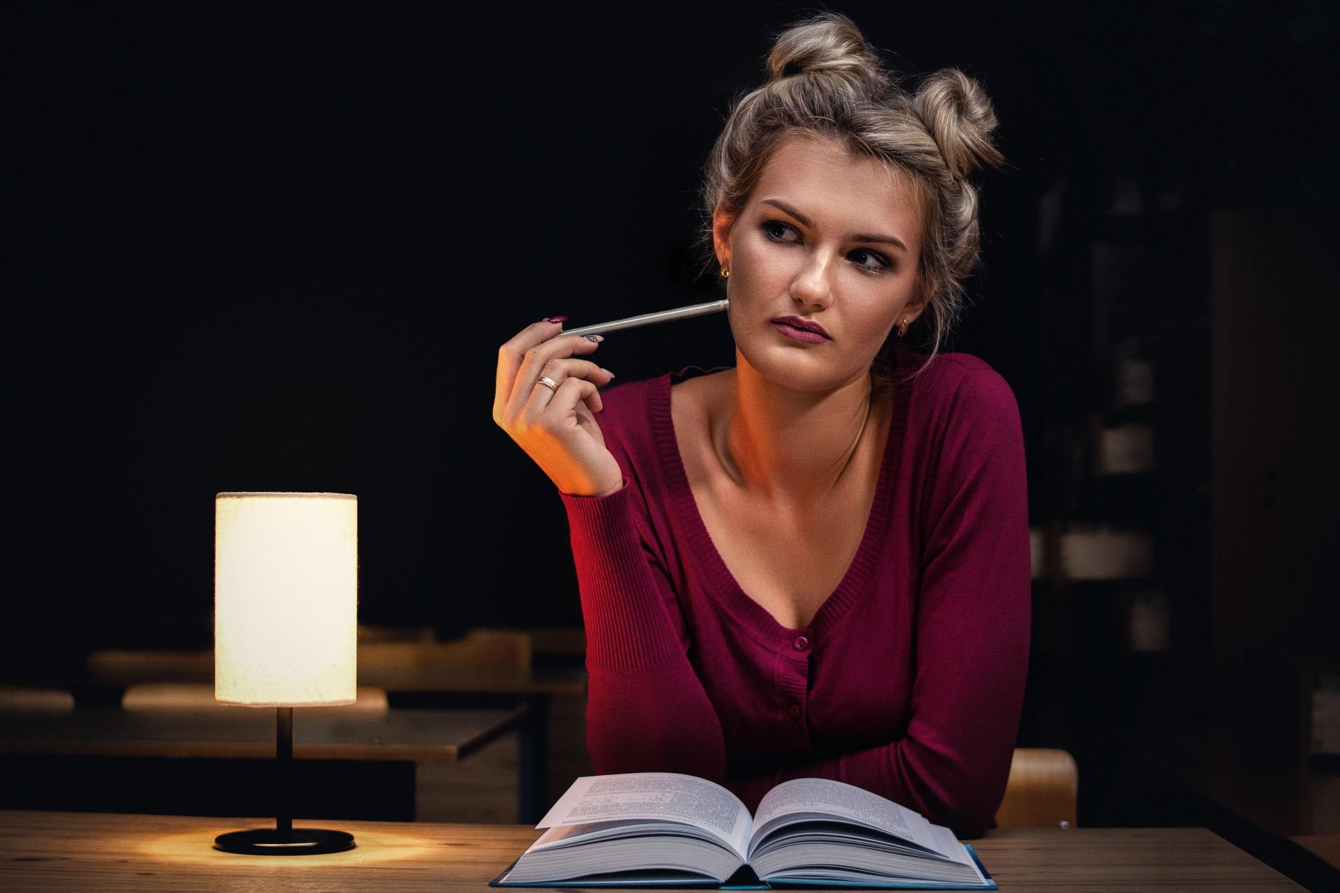 A woman pondering over a book