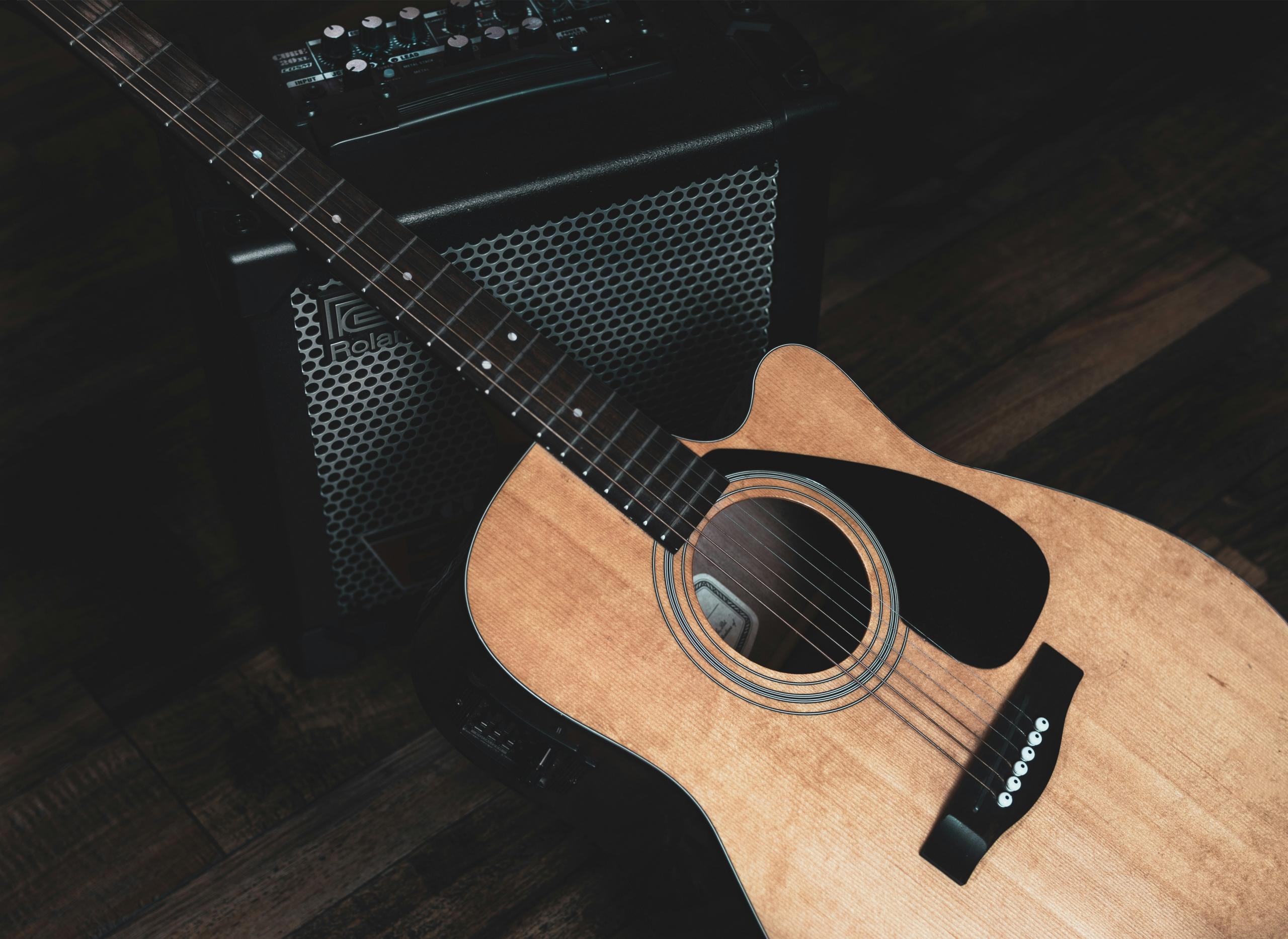 Electro-acoustic guitar with amplifier on floor