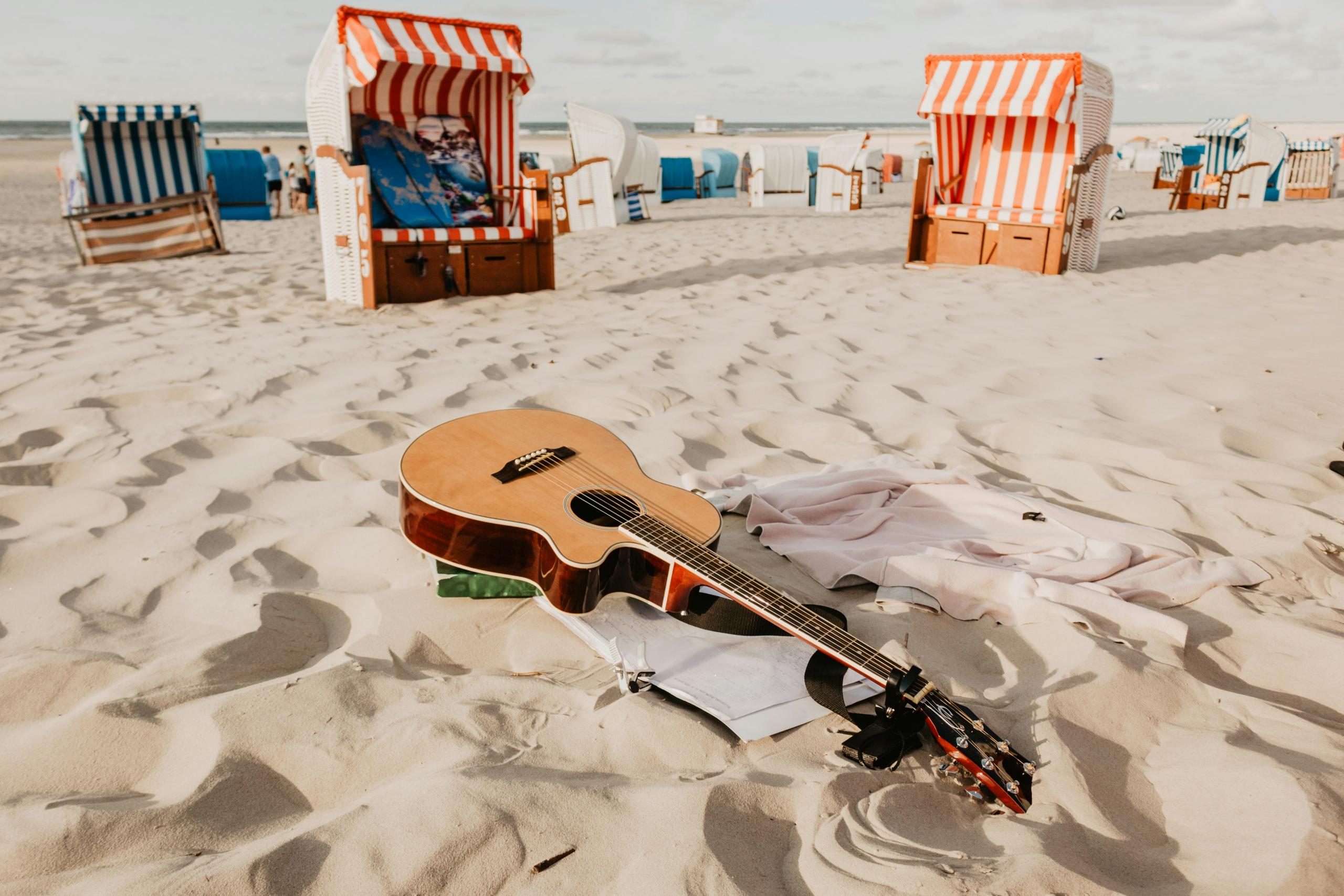 guitar at the beach with music sheet and kiosks