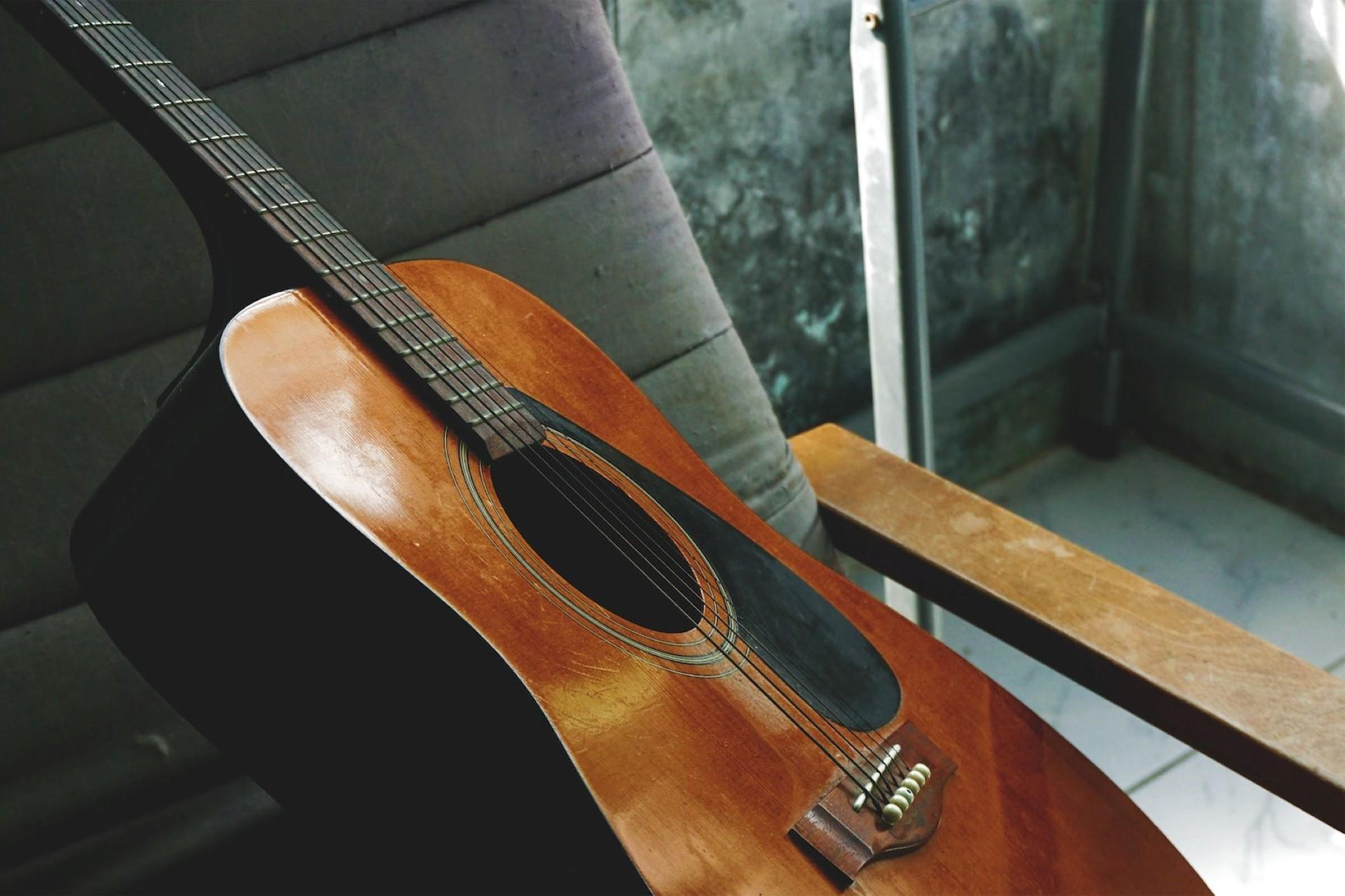 An acoustic guitar sitting on a chair.