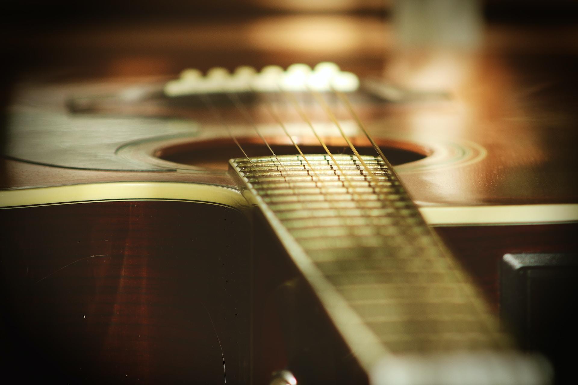A view of an acoustic guitar from the neck.