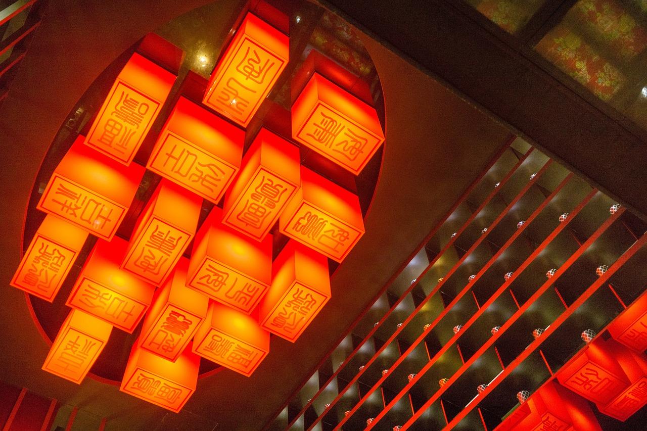 A decorative set of lights on the ceiling with Hanzi characters on them.