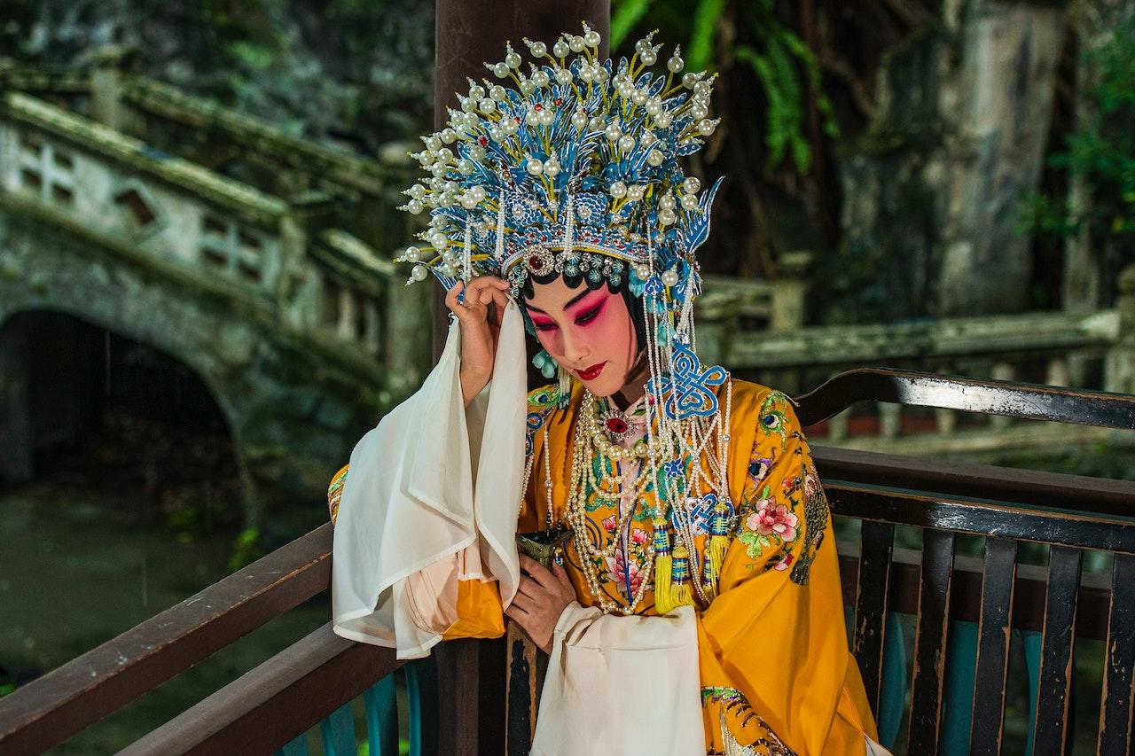 A Chinese opera actress wearing an ornate, colourful headdress, robe, and makeup.