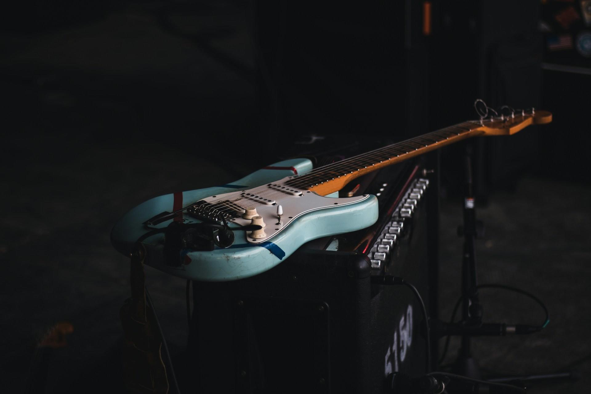 An electric guitar lying on an amp.