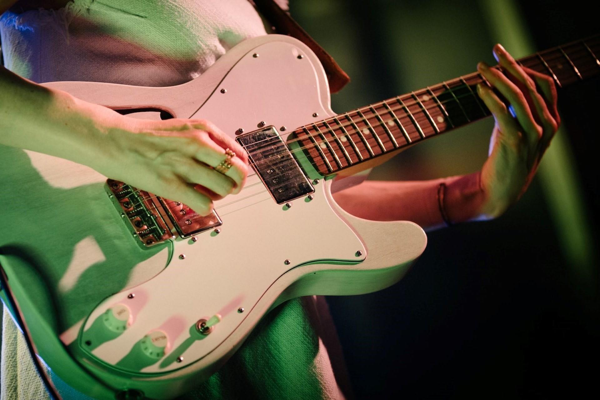 A person playing an electric guitar.