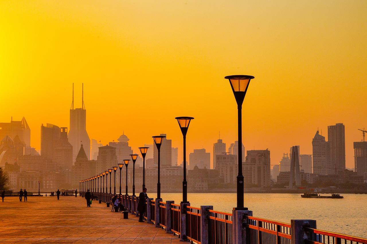 A bright yellow sky behind a view of Huangpu River bridge.