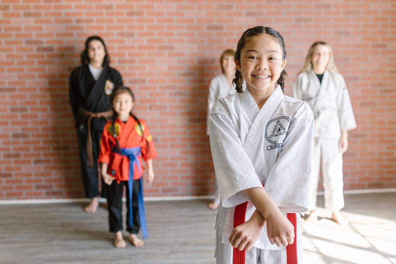 Young kung fu students smile for the camera.