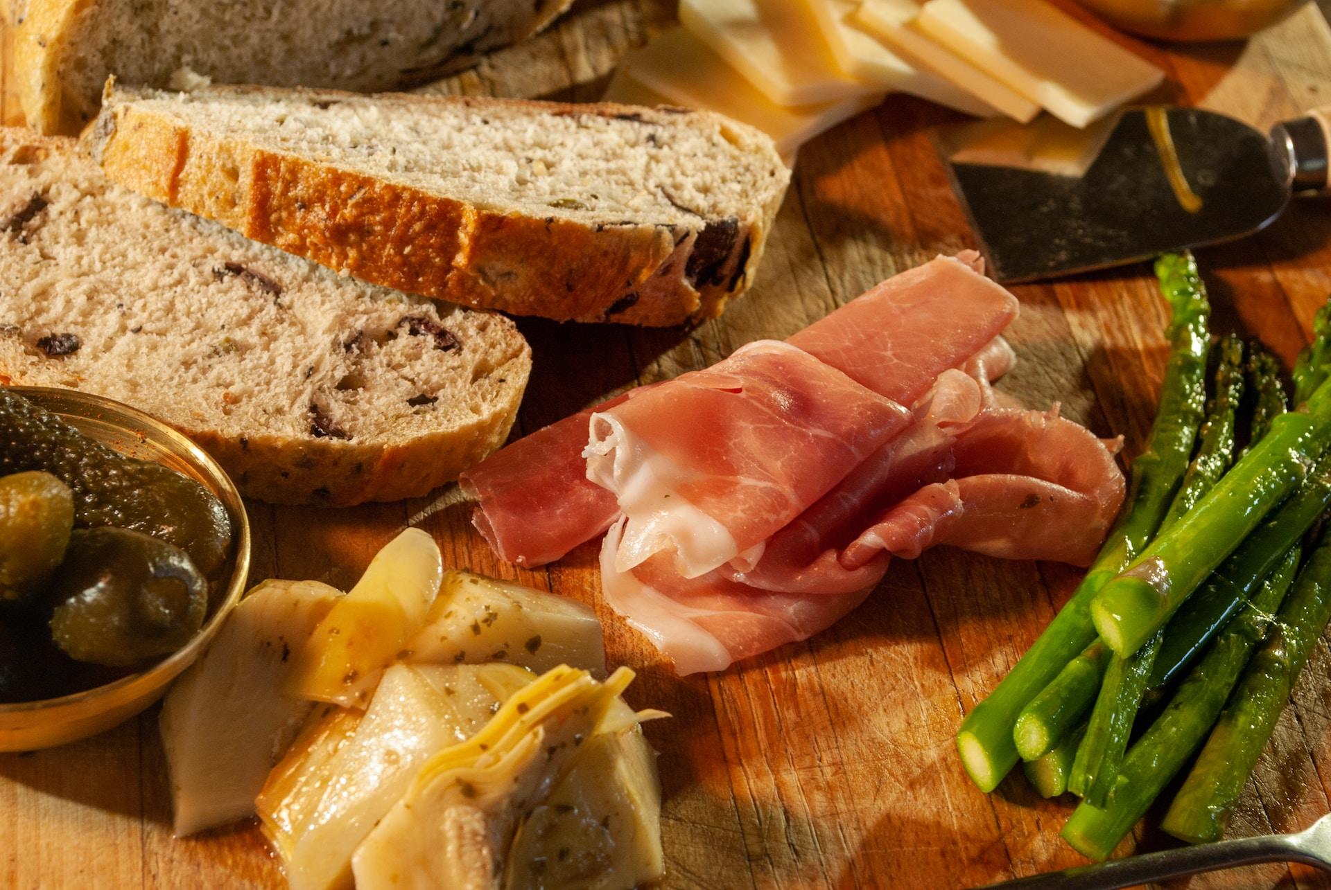 Bread, ham, asparagus, olives, and other antipasti.