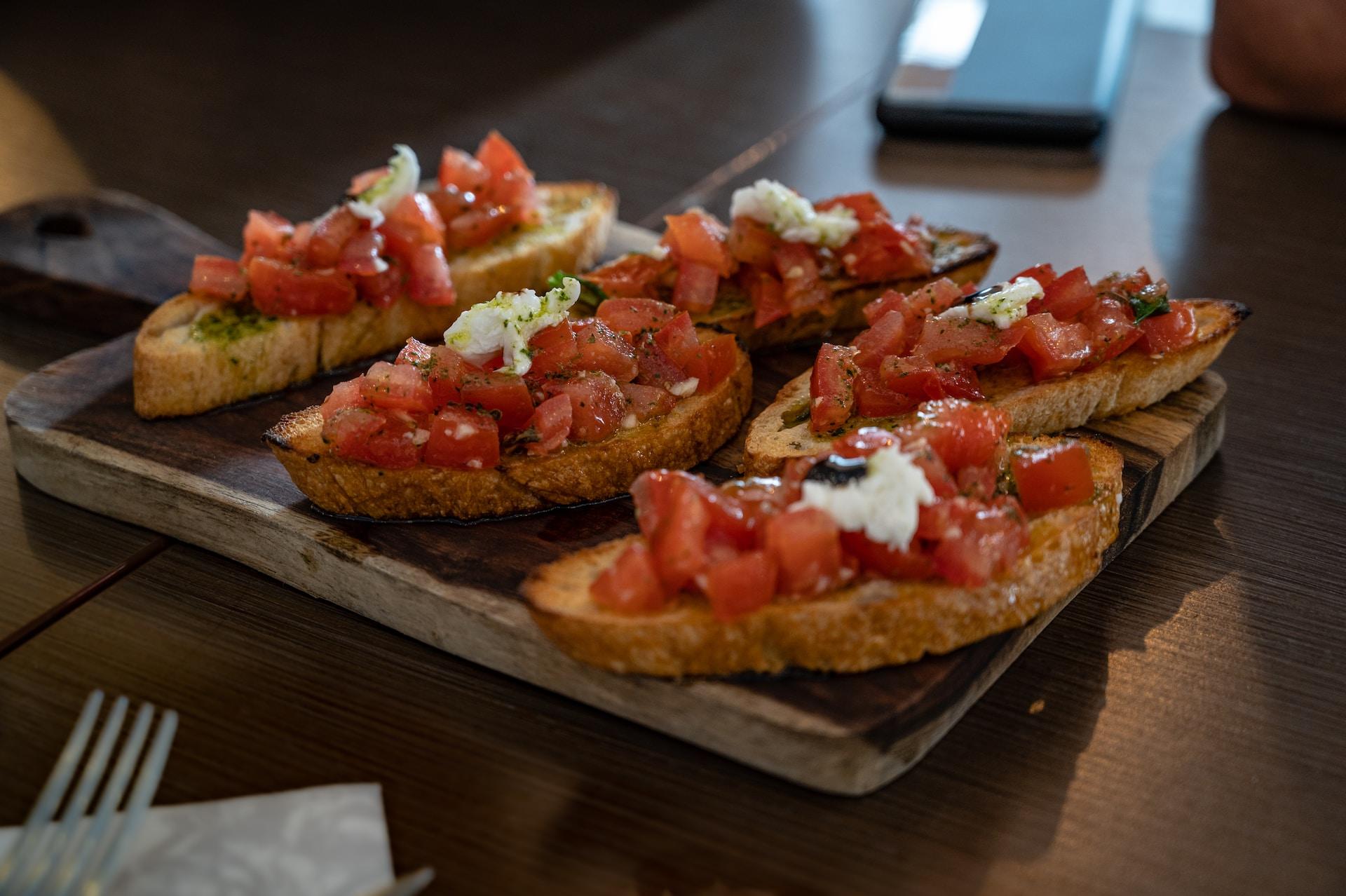 Several bruschette on a chopping board.
