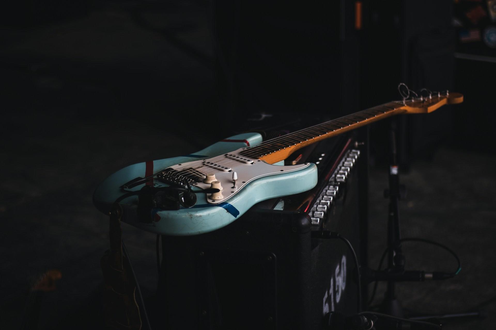A guitar lying on an amp.