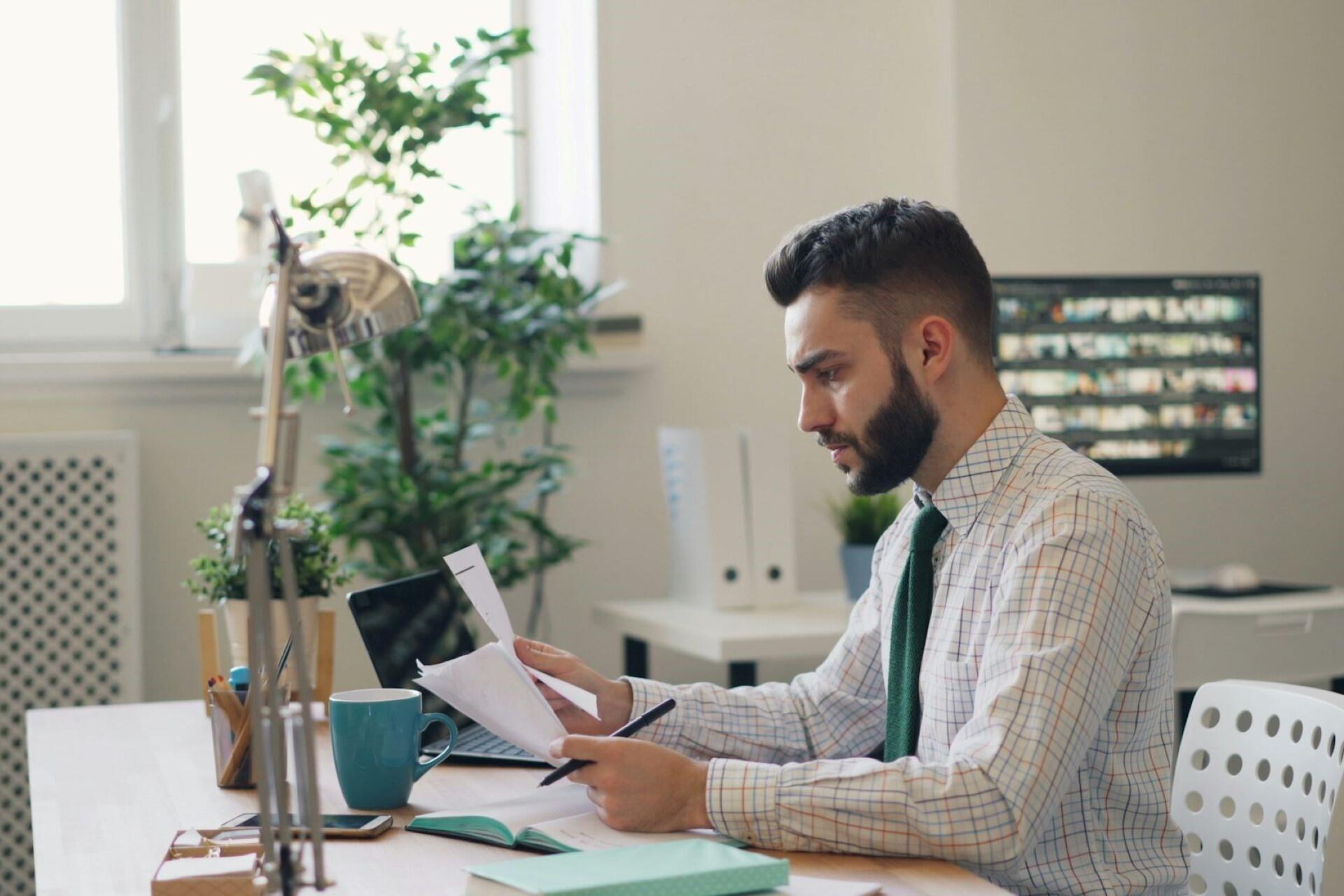 man reviewing printed financial documents at a desk