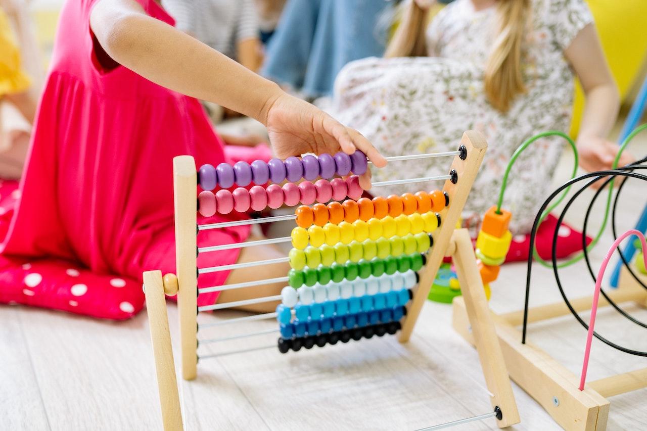 A colourful abacus being used by a toddler.