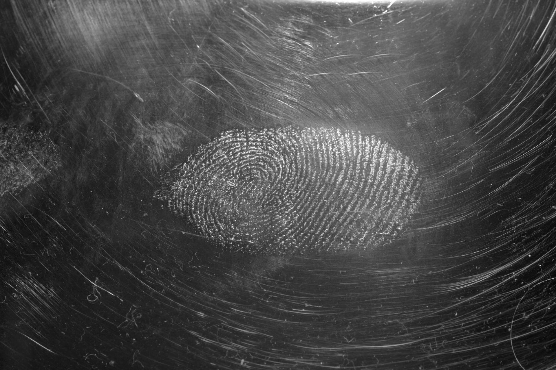 fingerprint on a scratched metallic surface