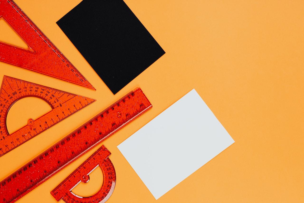 A spread of translucent orange maths tools against a lighter orange background.