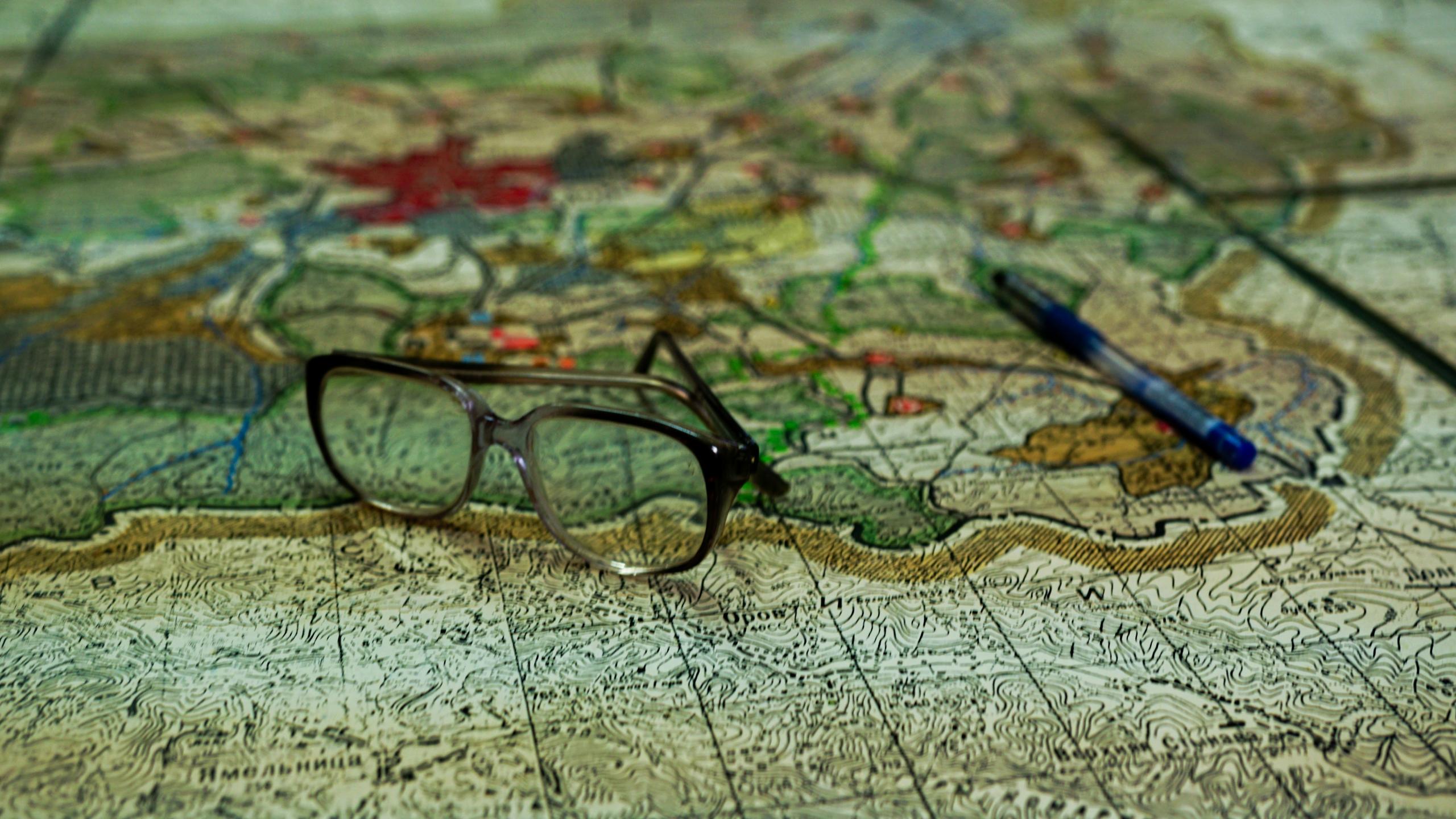 A pair of glasses sitting on a map