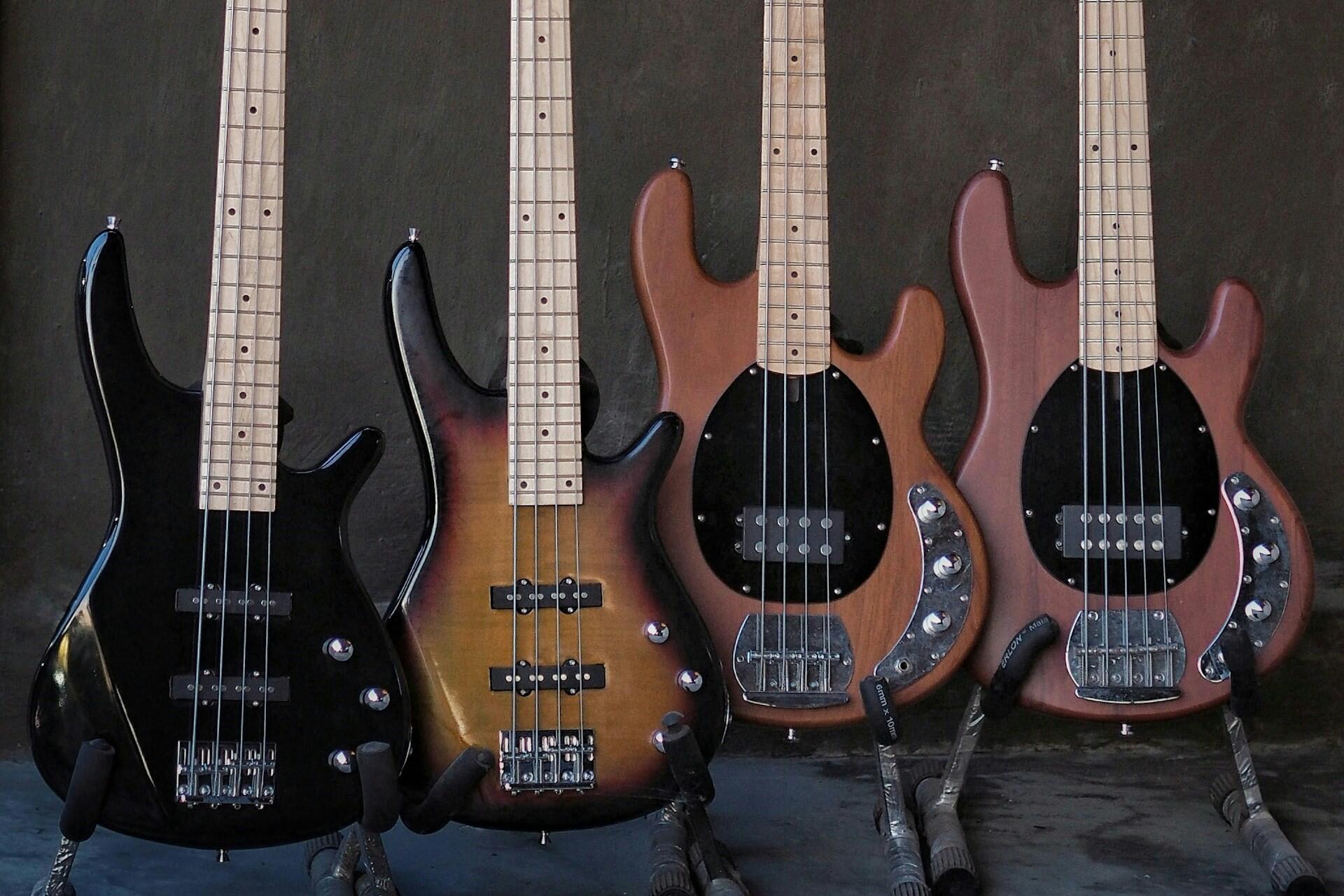 different bass guitars lined up on stands