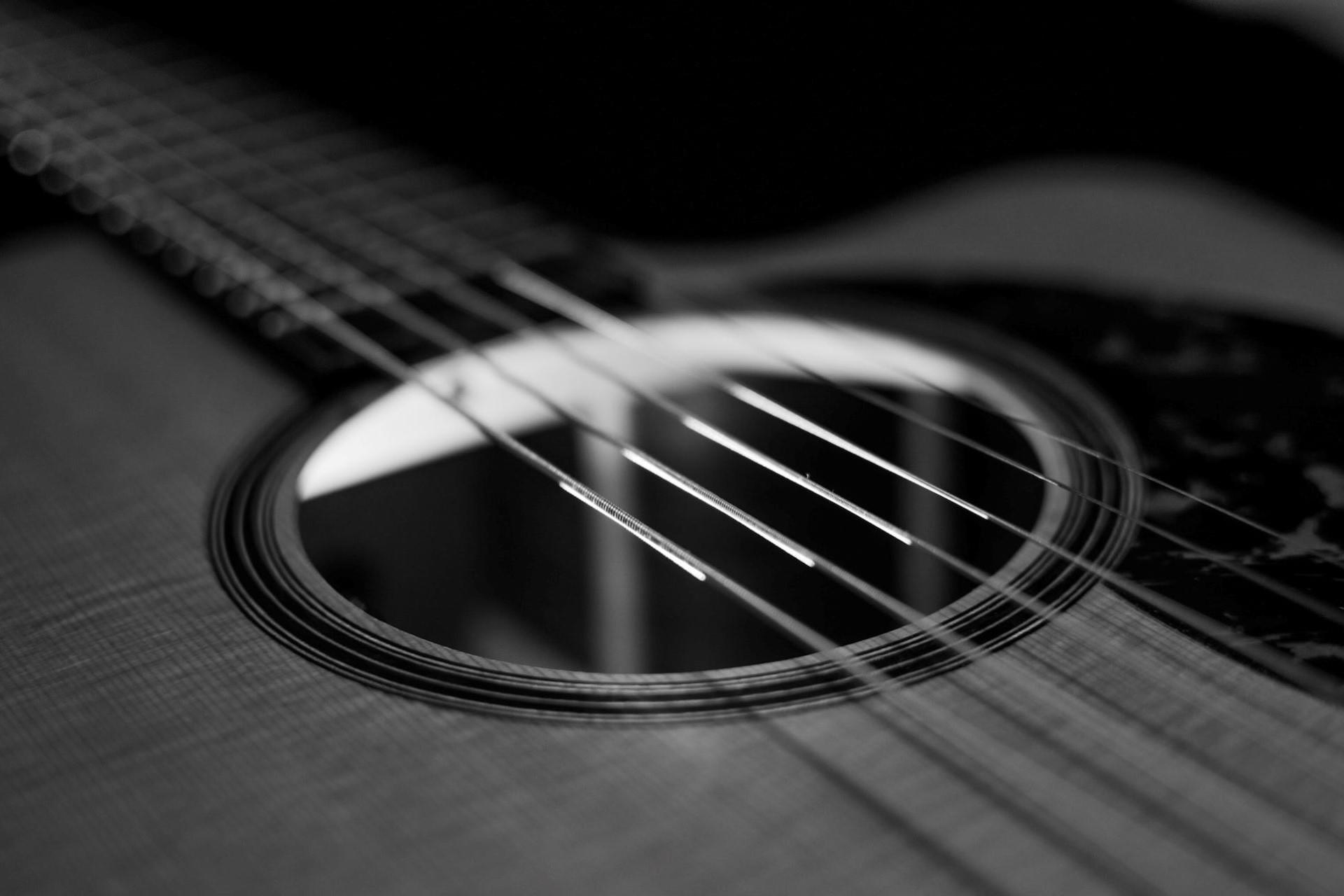 A black and white photo of a classical guitar's sound hole.