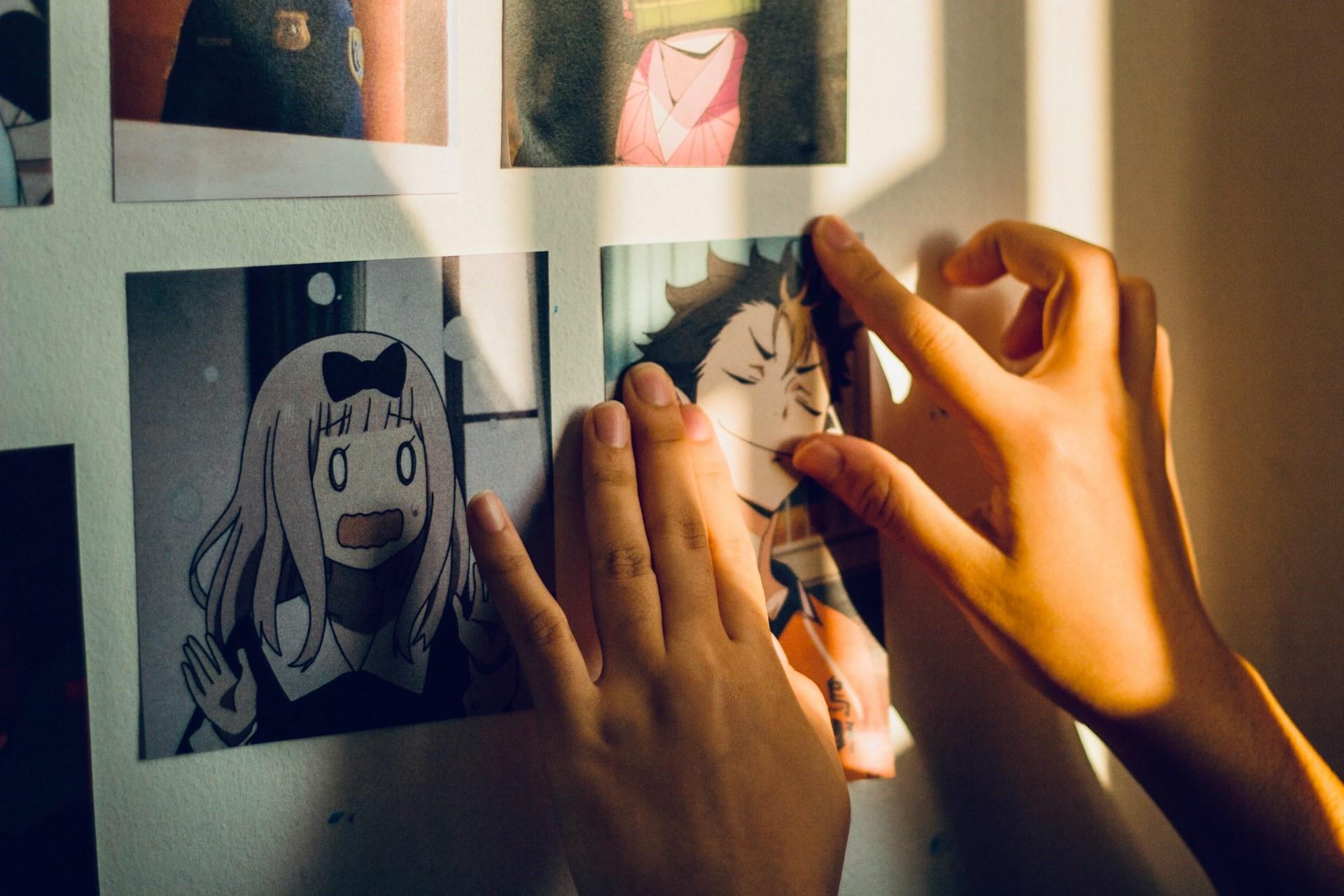 Anime postcards on a wall.