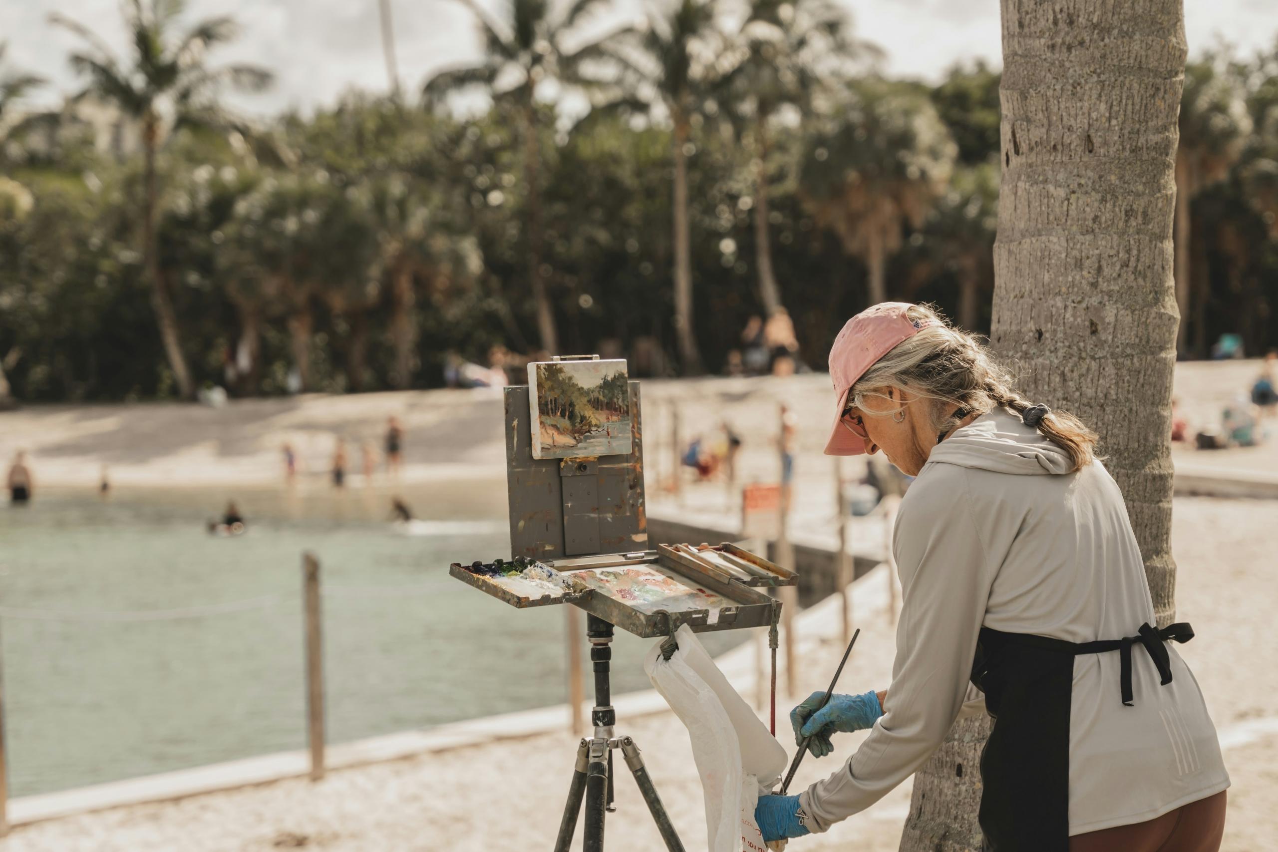 Woman painting canvas at the beach