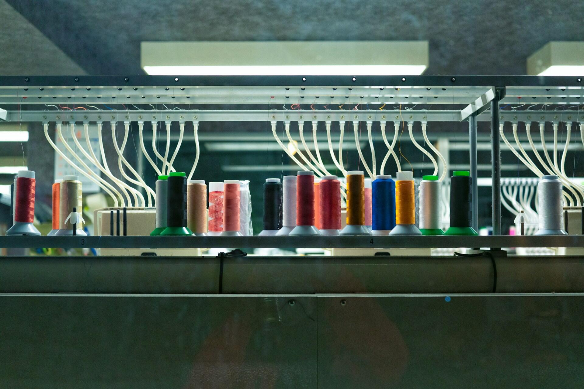 Colourful thread spools lined up on an embroidery machine