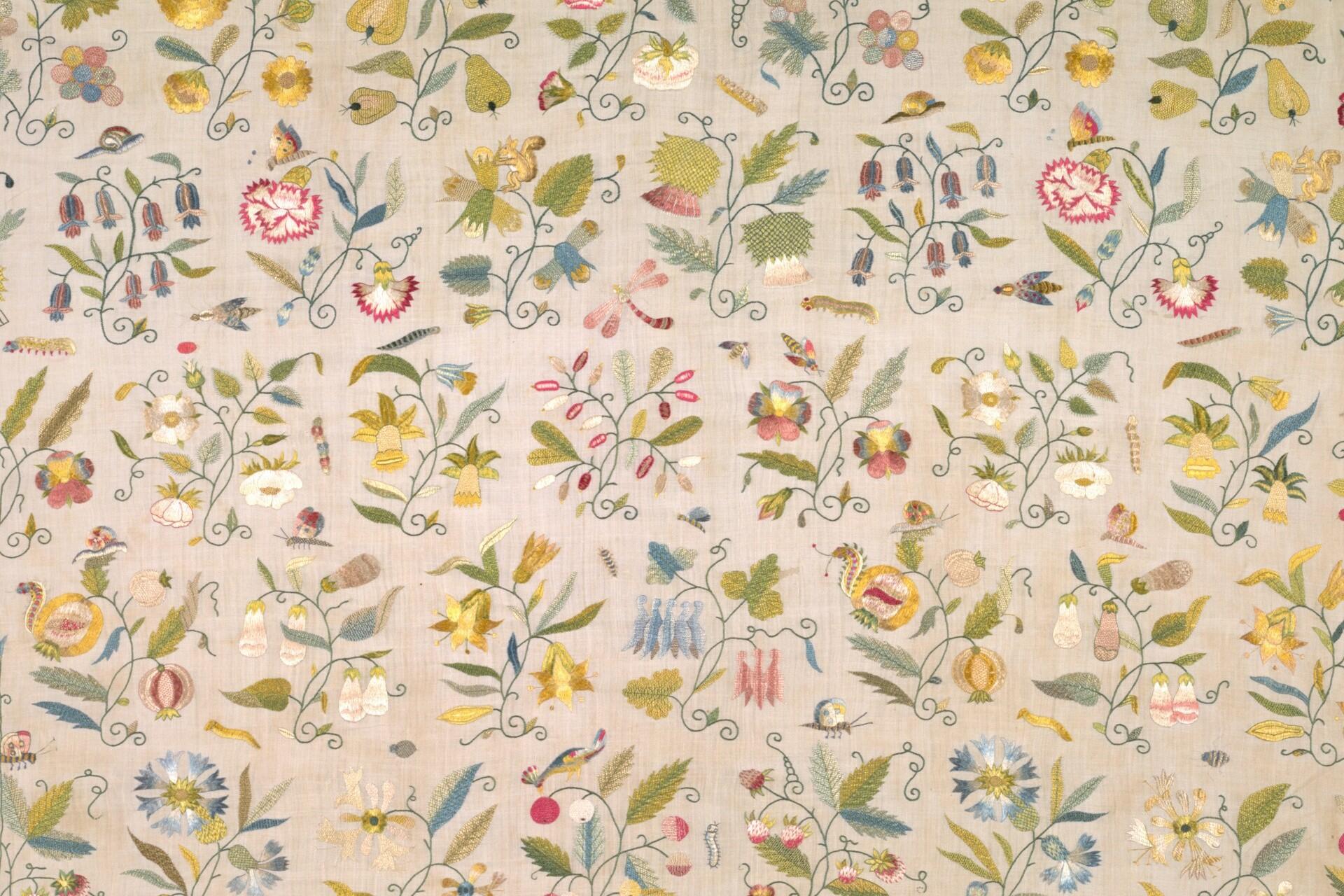 Floral and animal embroidery on pale fabric