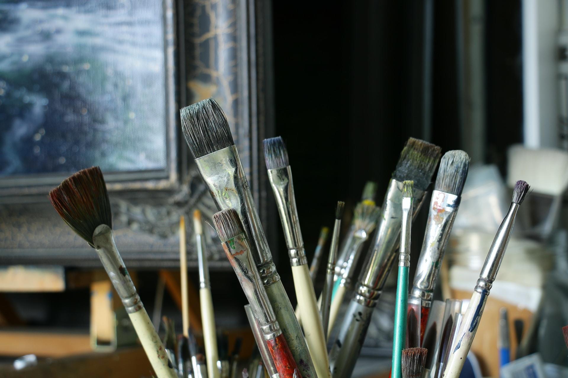Some paintbrushes in a pot.