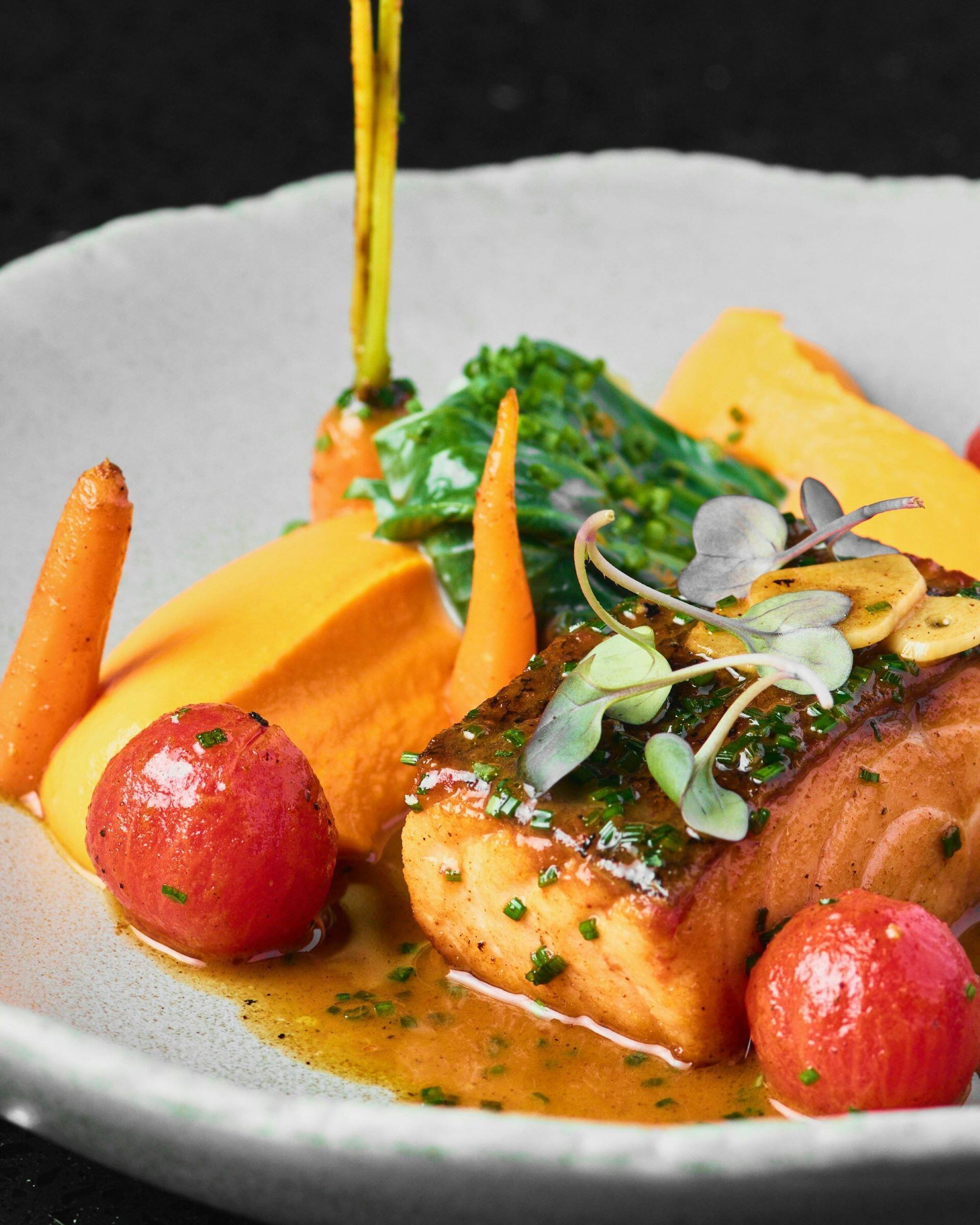 Salmon fillet served with carrots and green vegetables