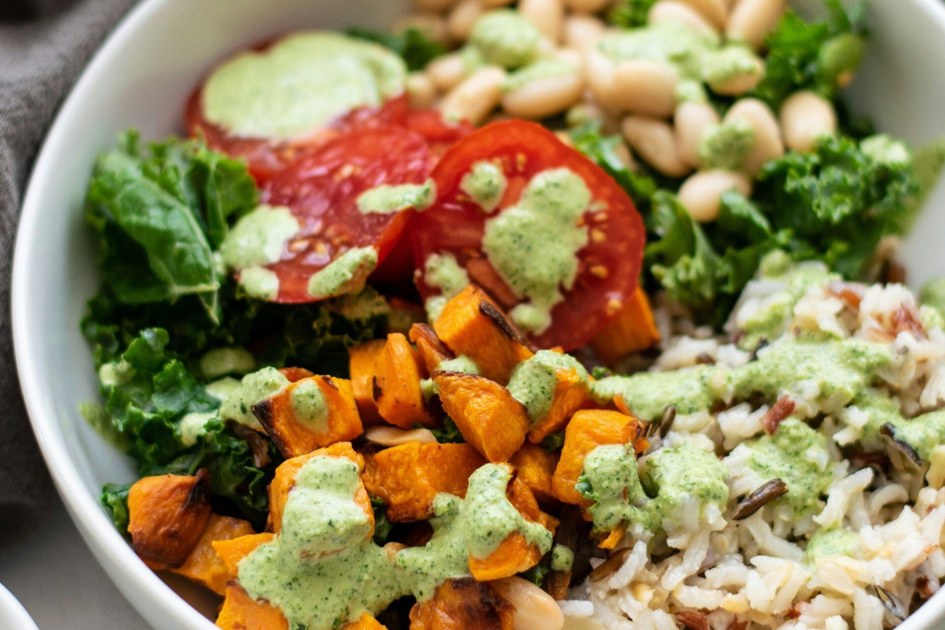Bowl with rice, beans, roasted vegetables and leafy greens