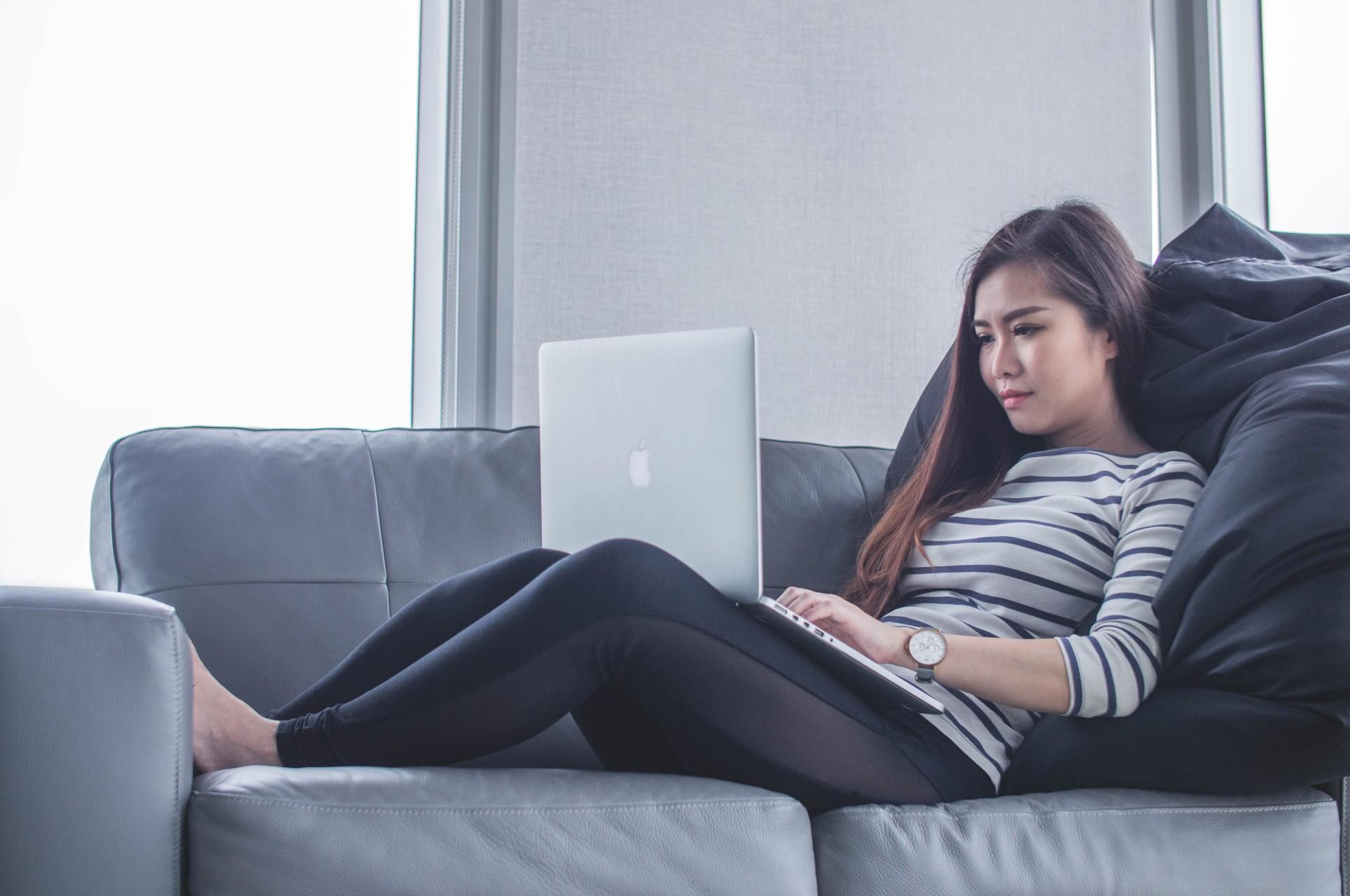 A woman with a laptop on a couch