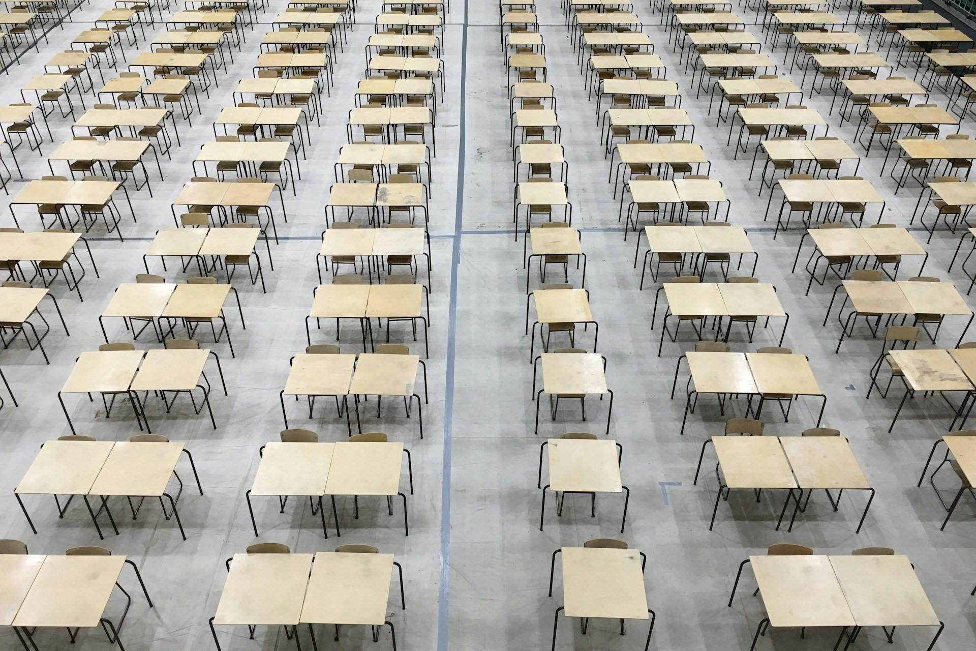Rows of desks in an exam hall.