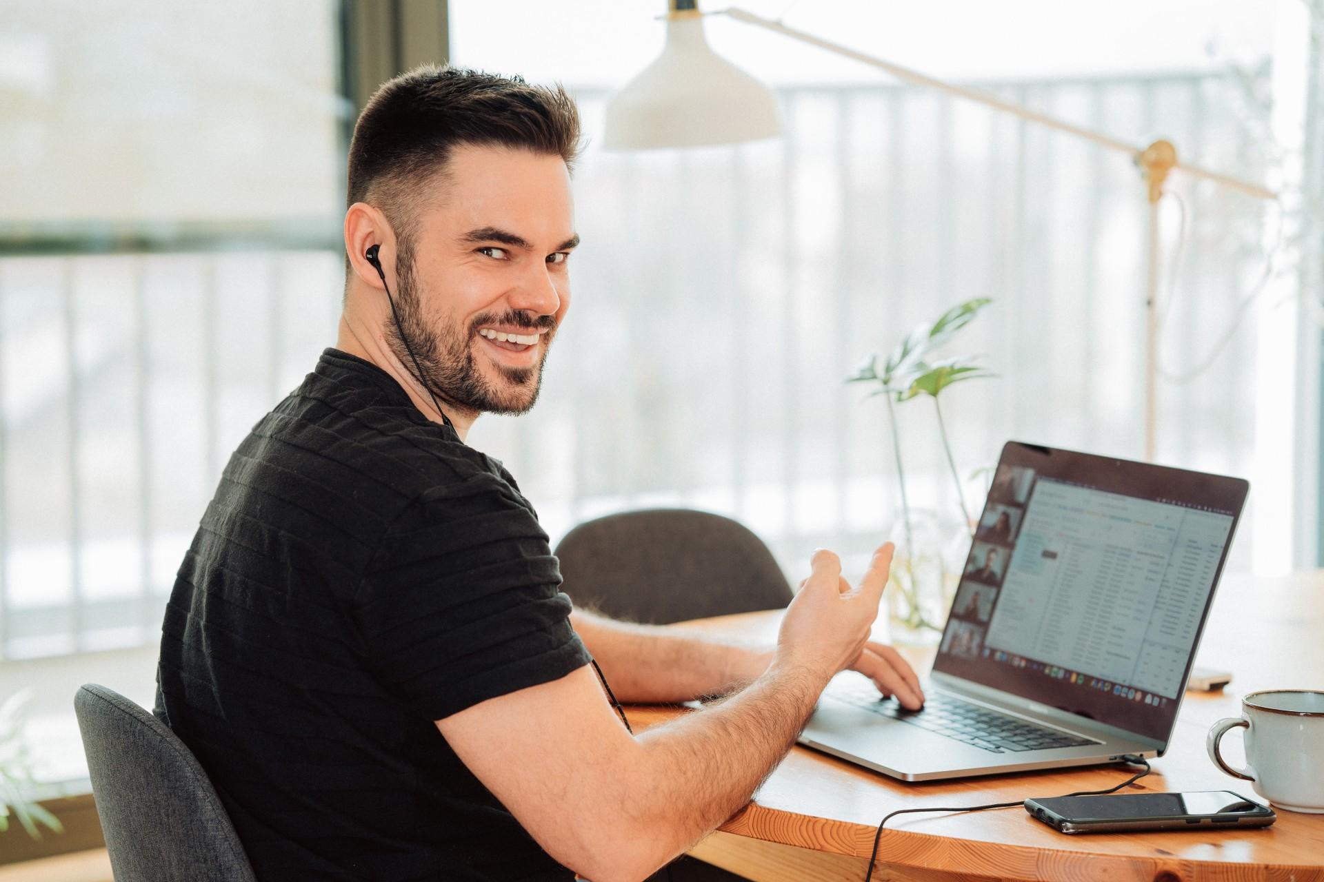 A happy man in front of his computer