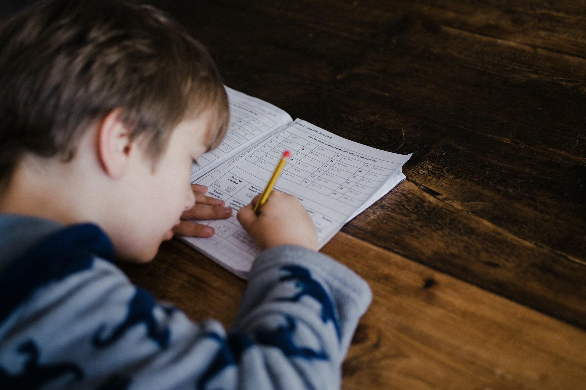 A boy doing exercises in an exercise book.
