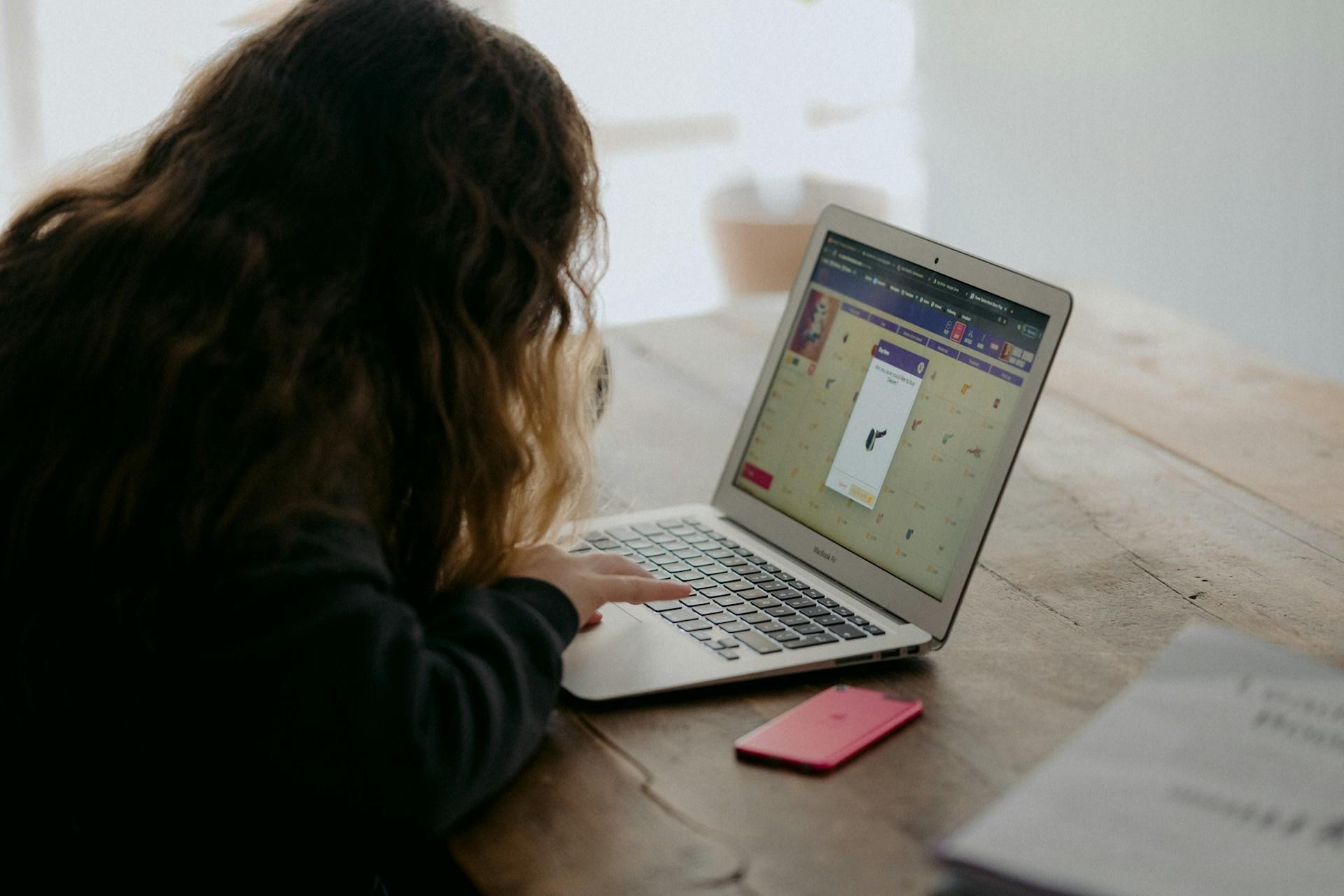 A child lying down and using a laptop.