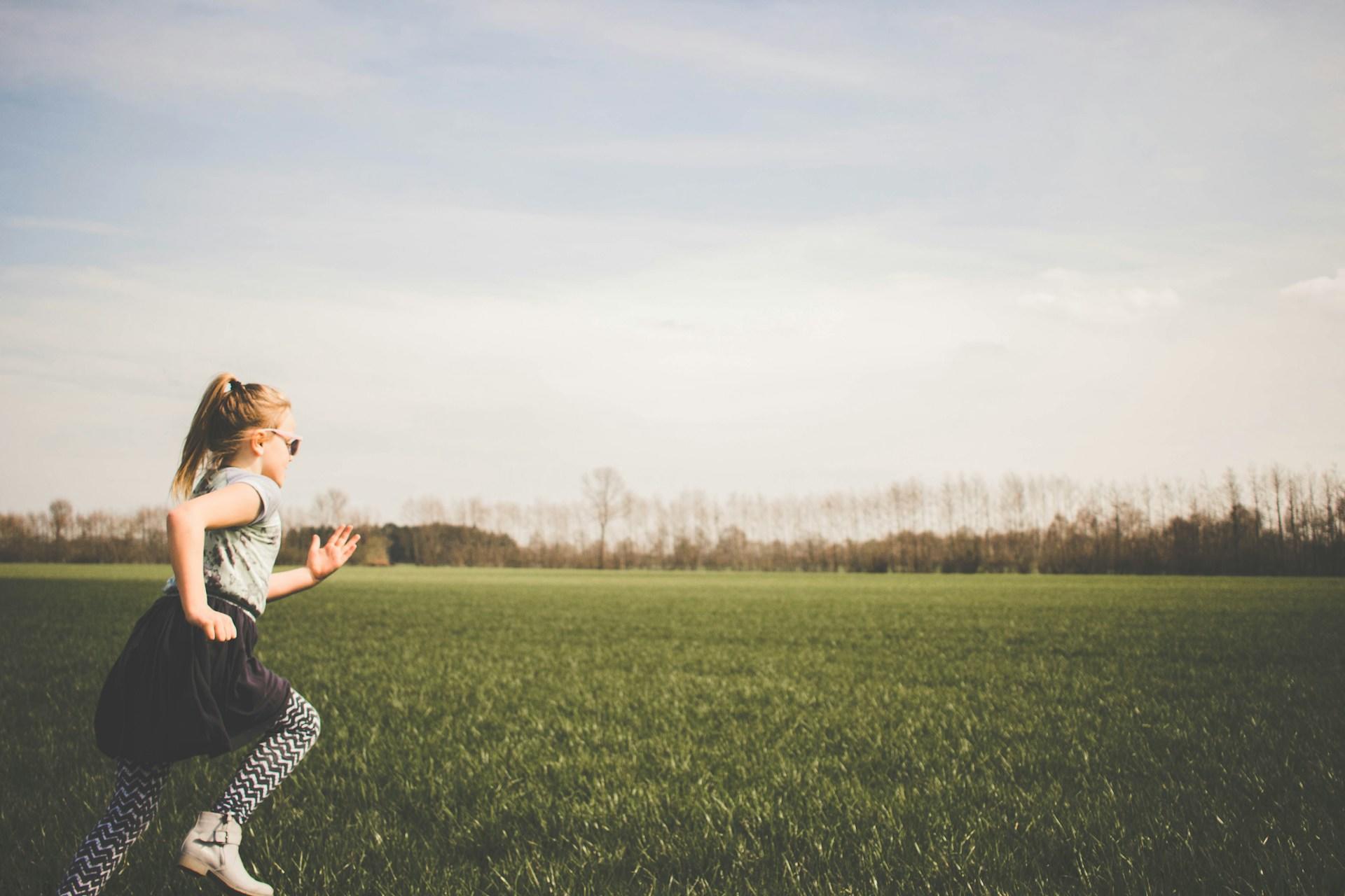 A girl running in a field.