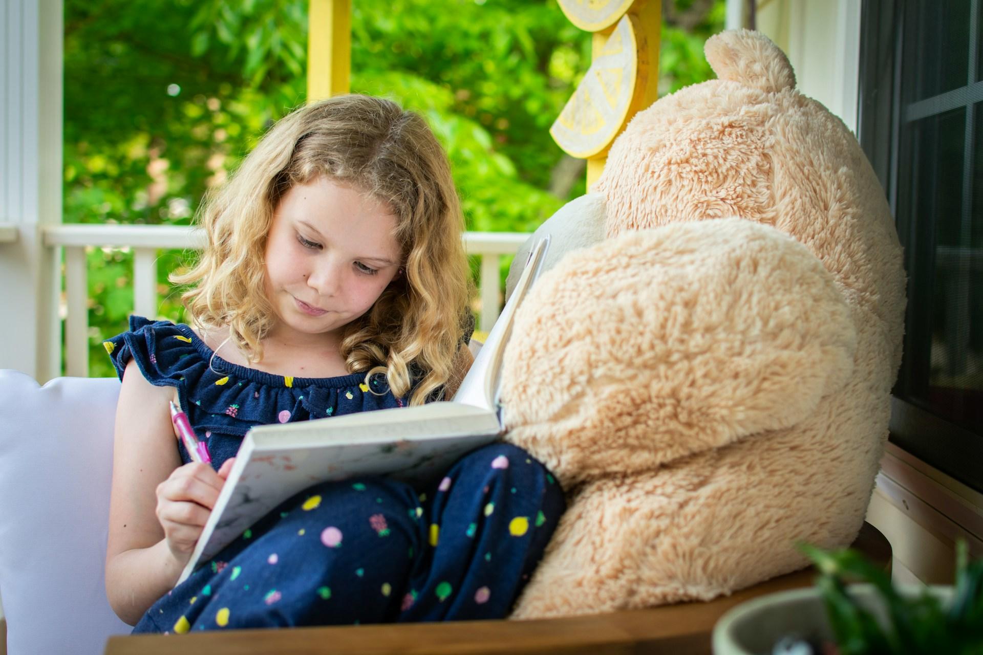 A girl sitting down with an exercise book.