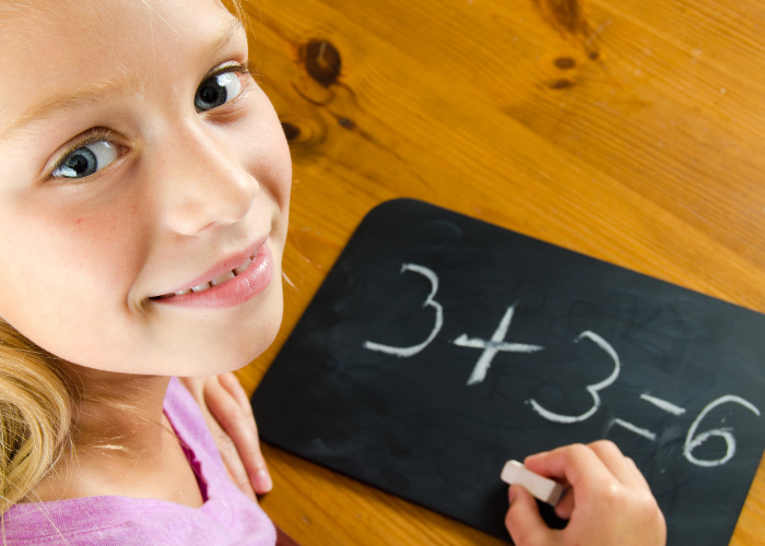 girl learning basic addition chalkboard