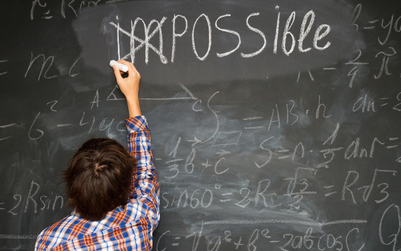 Boy do maths calculations blackboard