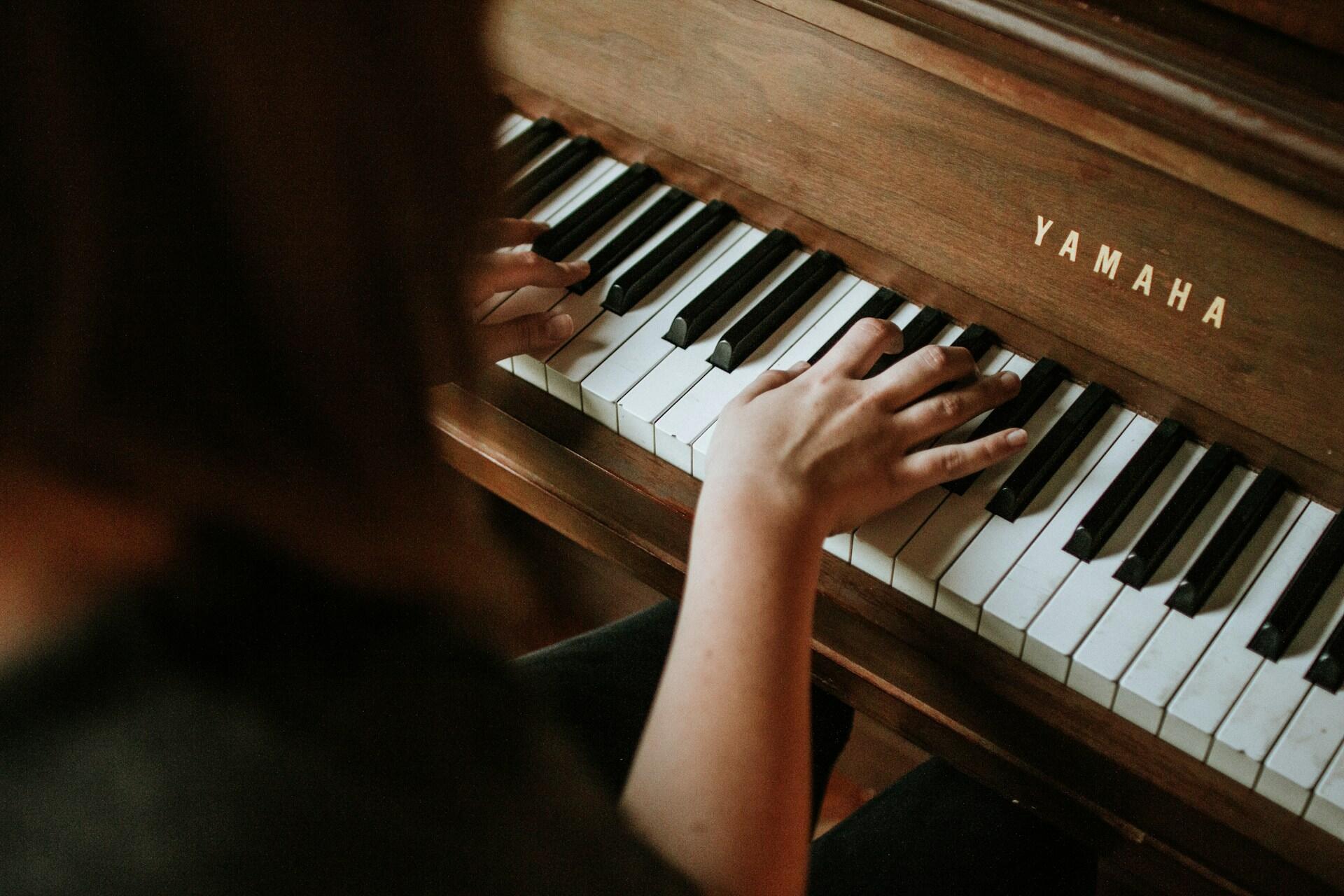 Hands playing a Yamaha piano