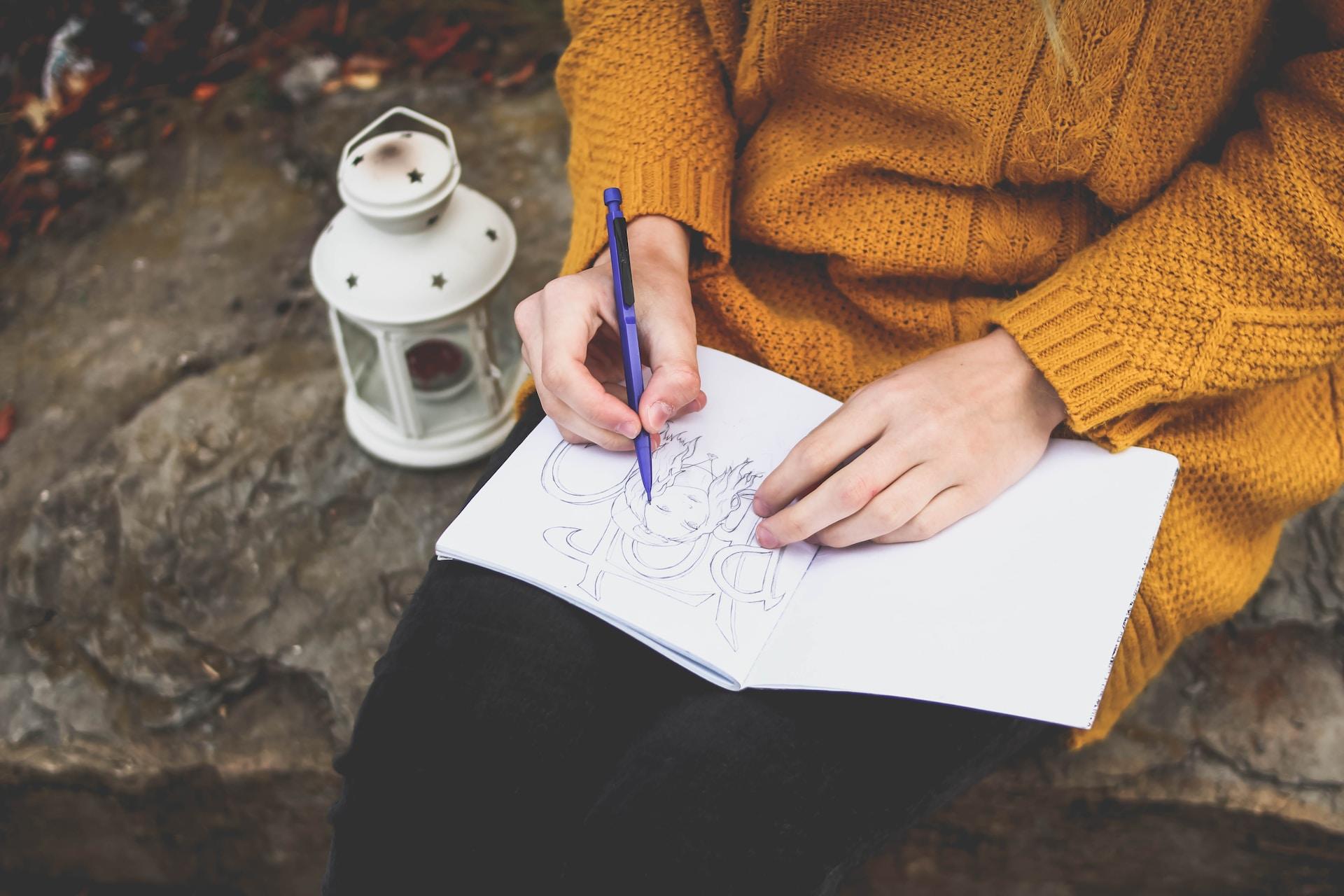 A person sitting down and drawing.