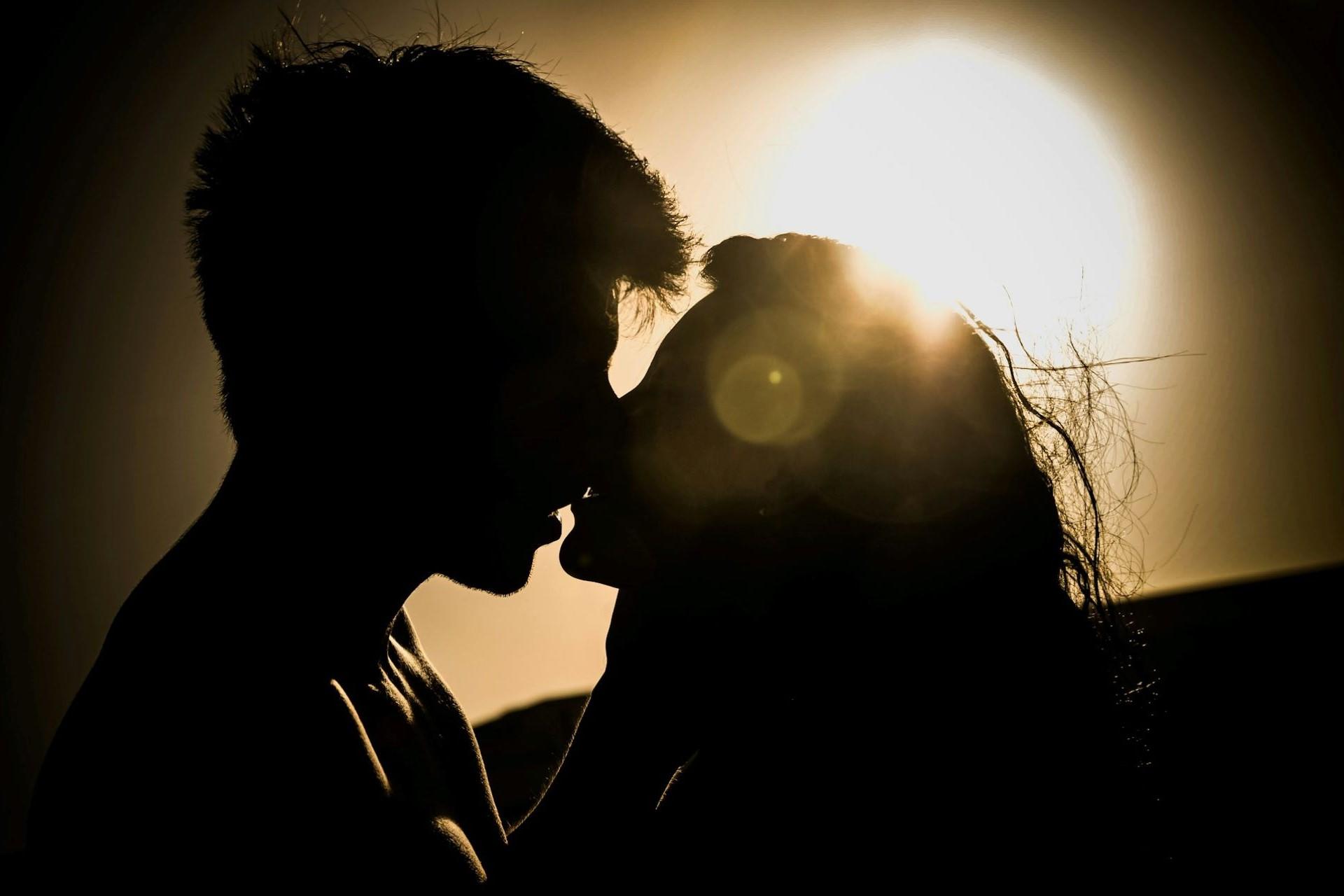 A silhouetted couple about to kiss.