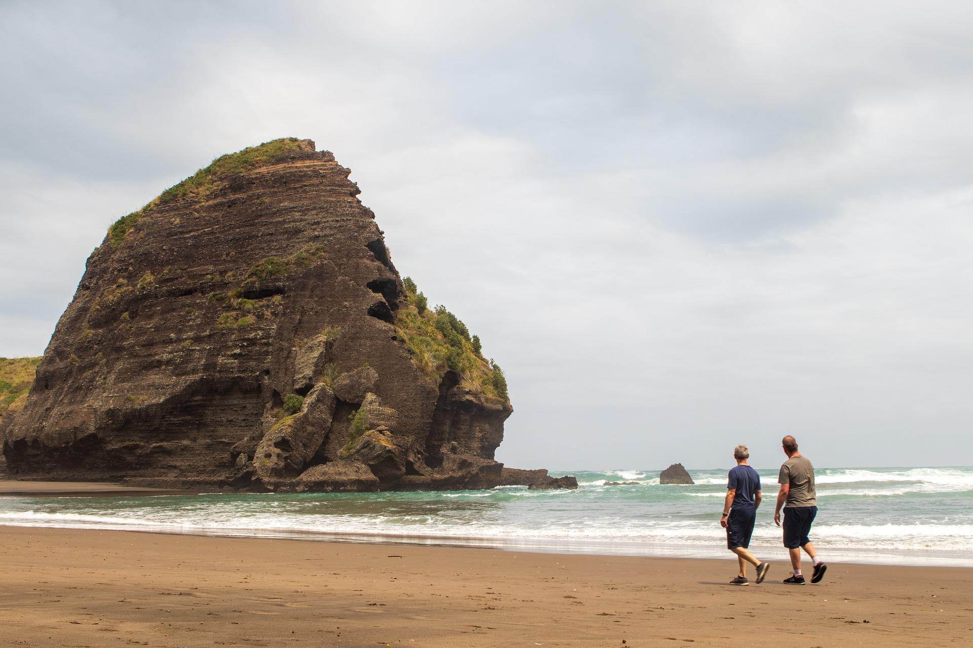 Two people walking on the beach practicing English