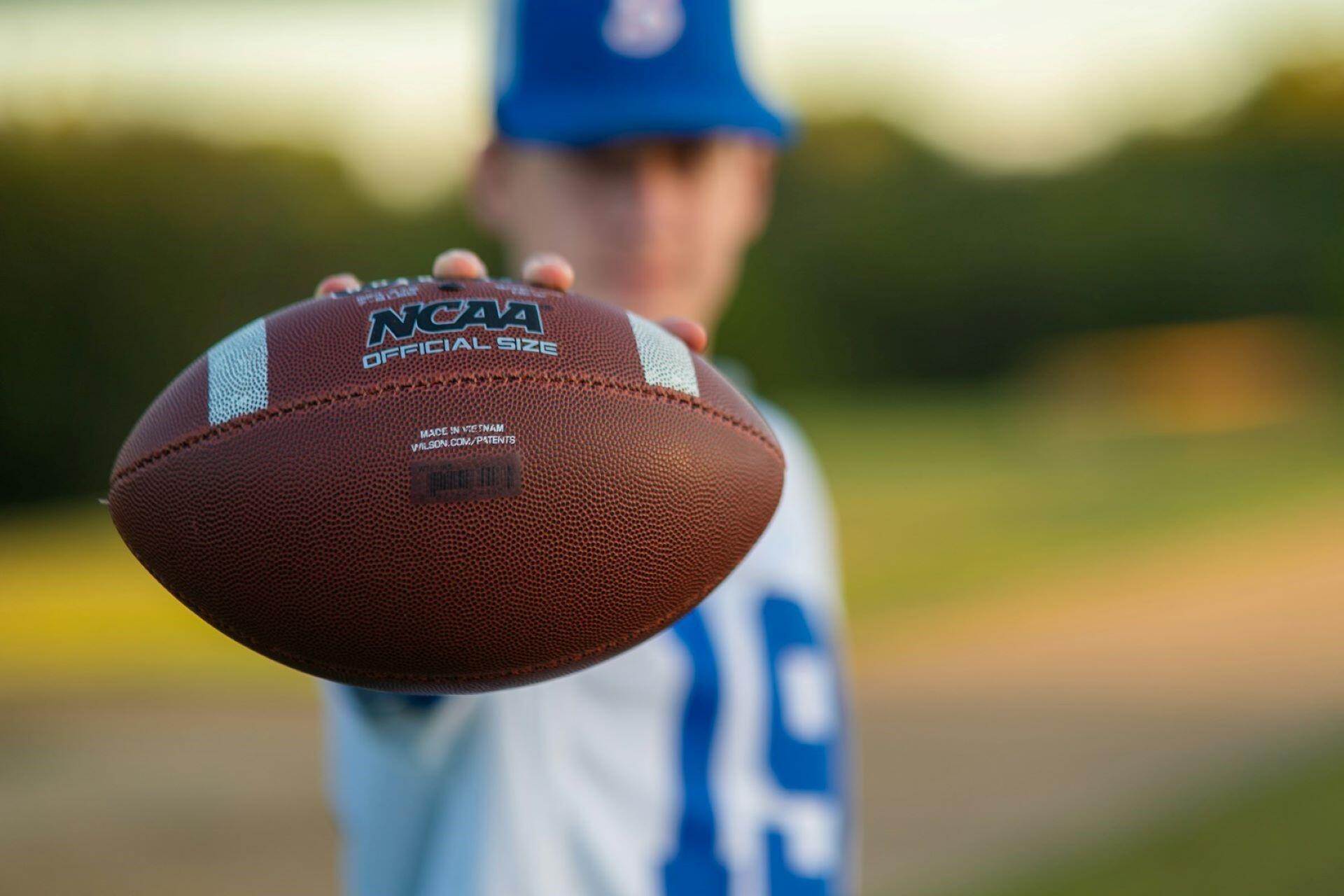 A player holding an NCAA football.