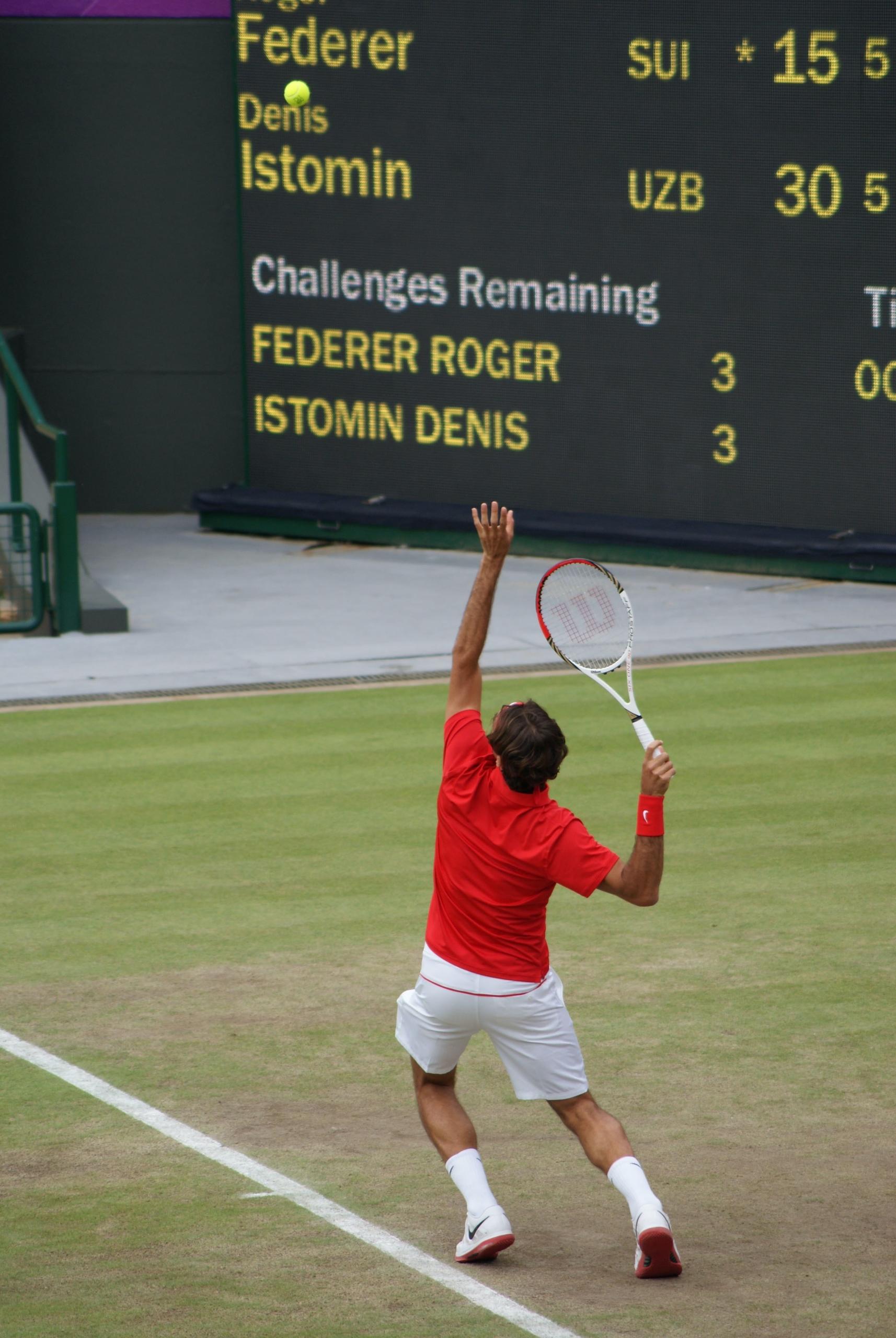 Federer playing tennis on grass court