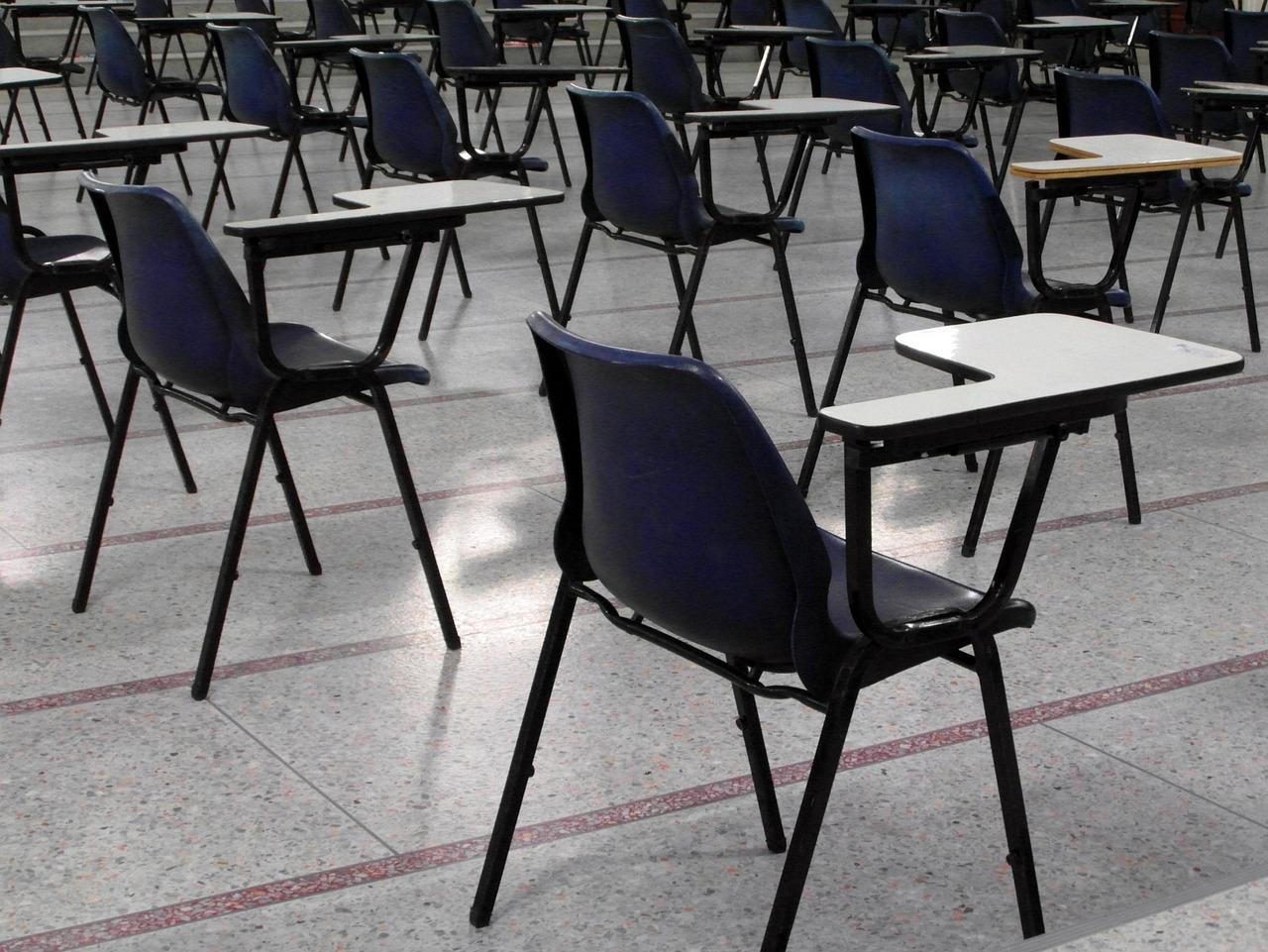 Empty chairs with attached desks set up for an exam