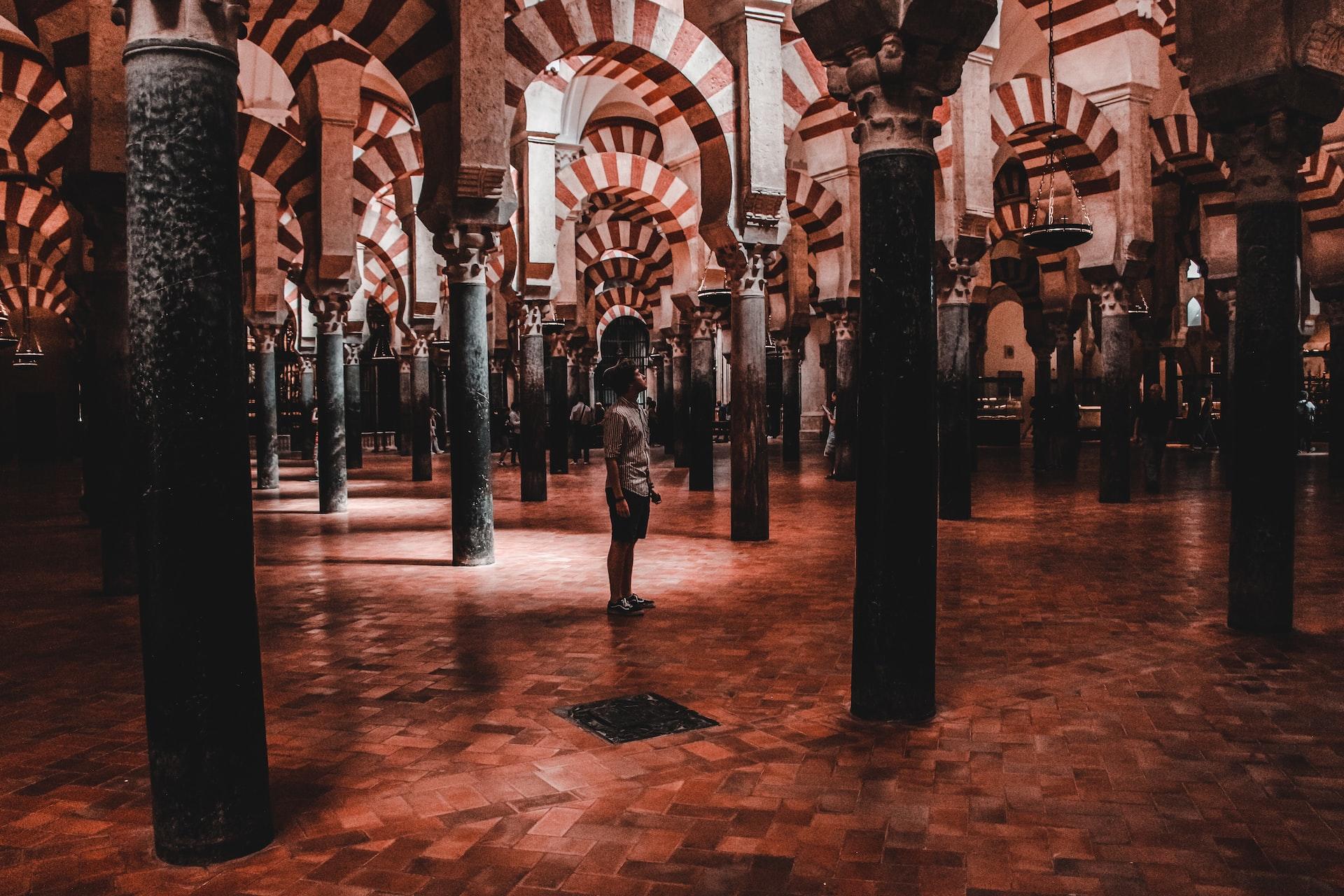 A man standing beneath an old architecture