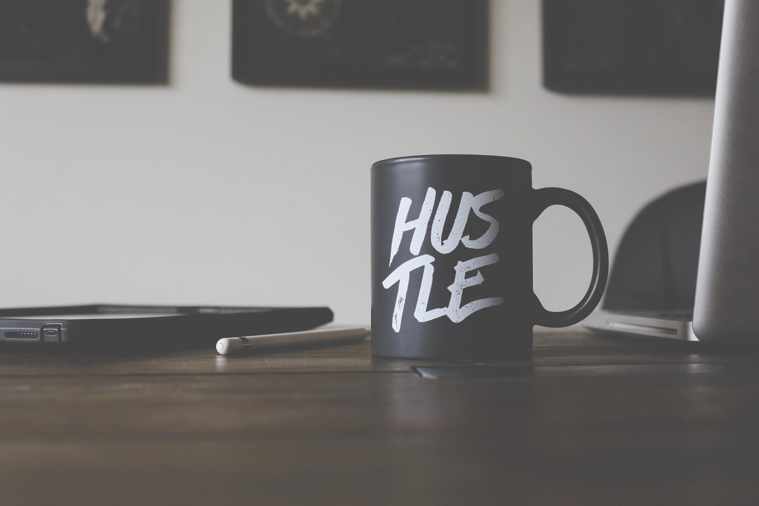 cup with hustle written on it